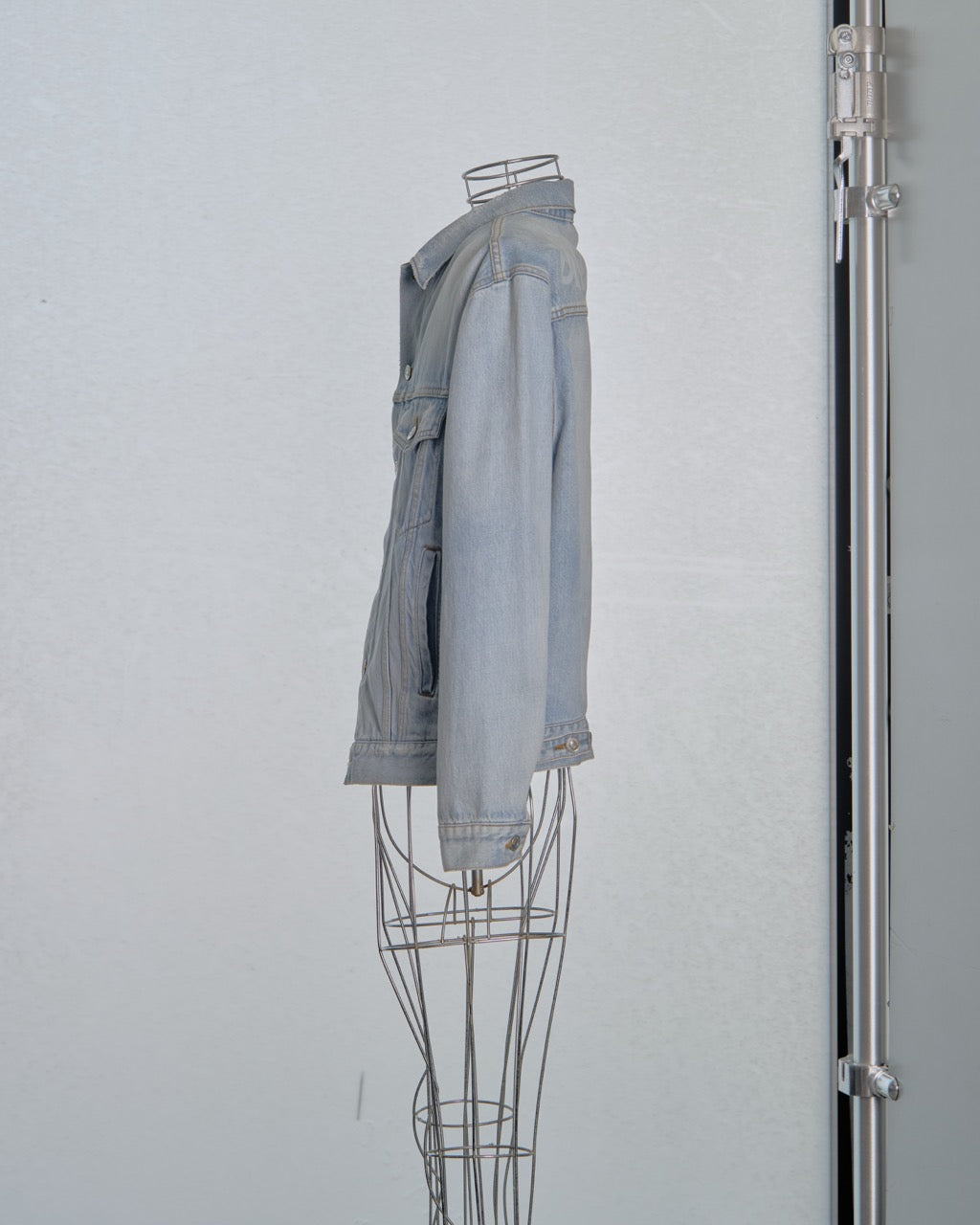 Gray denim Balenciaga jacket on a wire mannequin against a white background