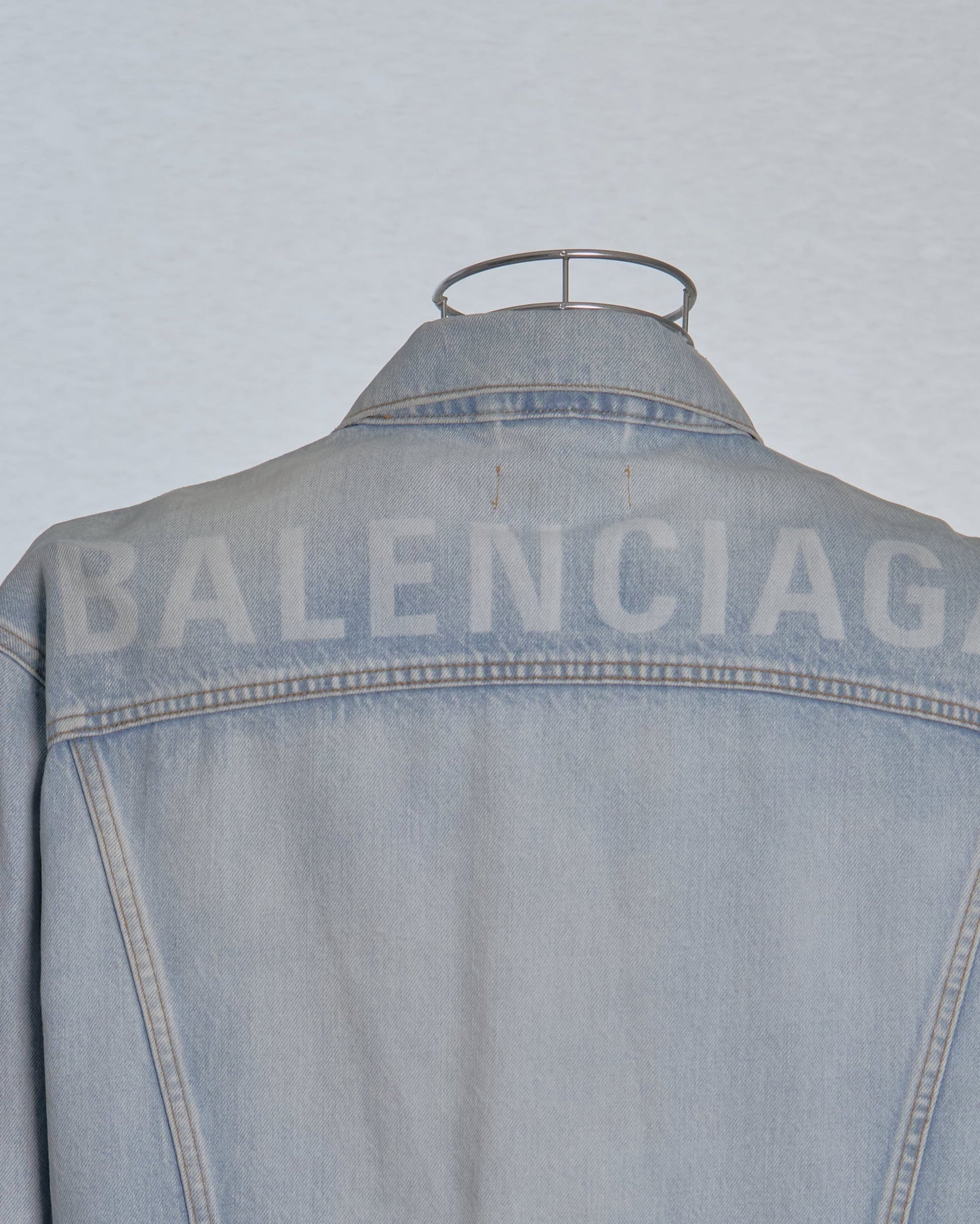 Denim jacket with 'BALENCIAGA' branding on a light gray background
