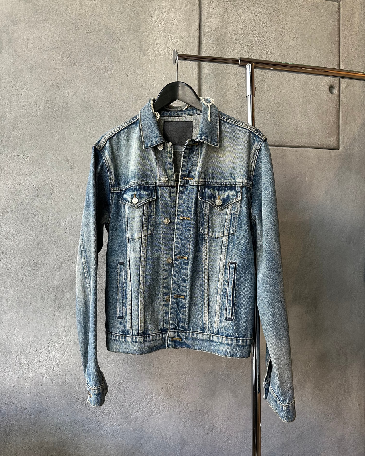 Blue denim jacket with Balenciaga logo on a gray background