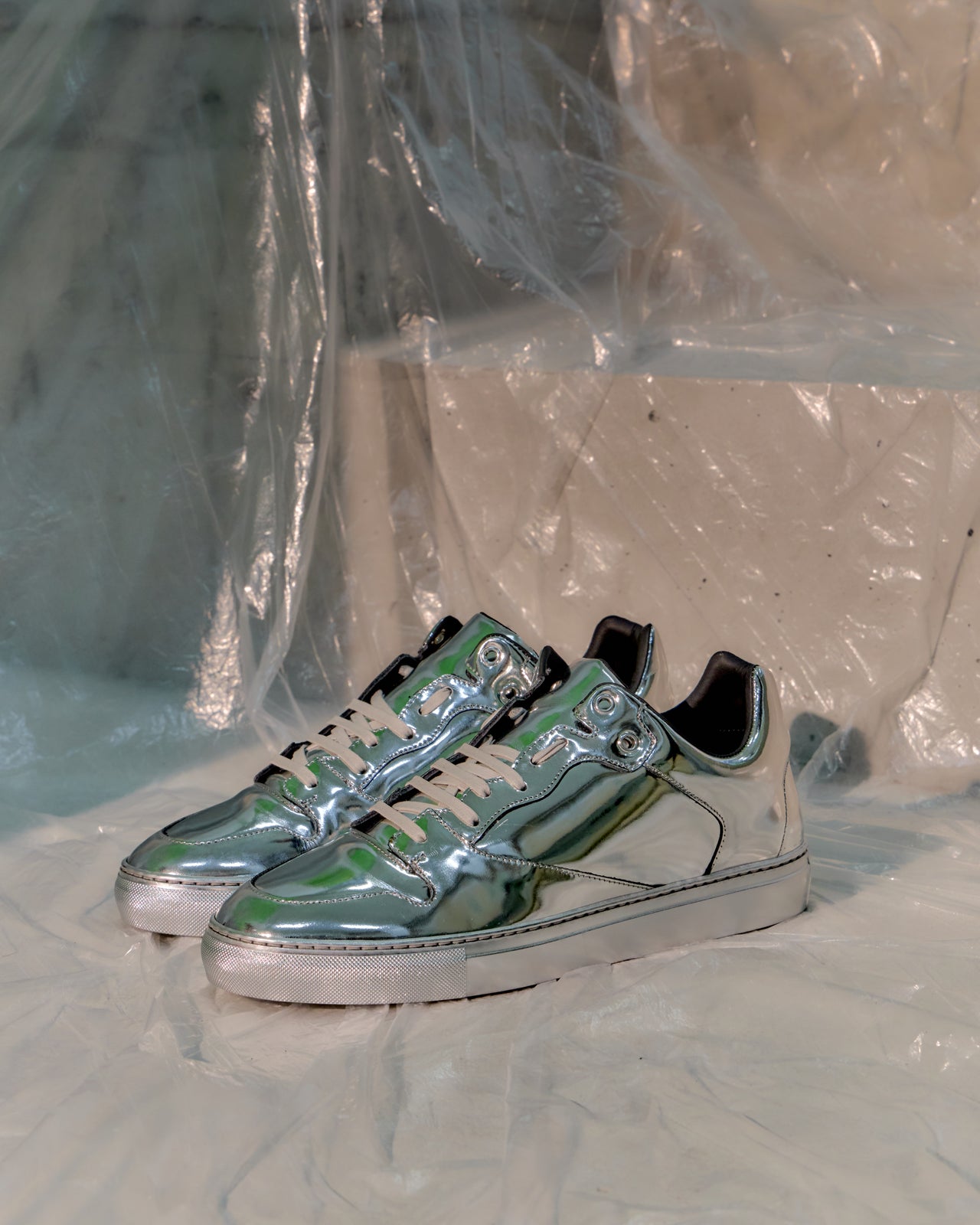 Silver Balenciaga sneaker with green accents on a white background
