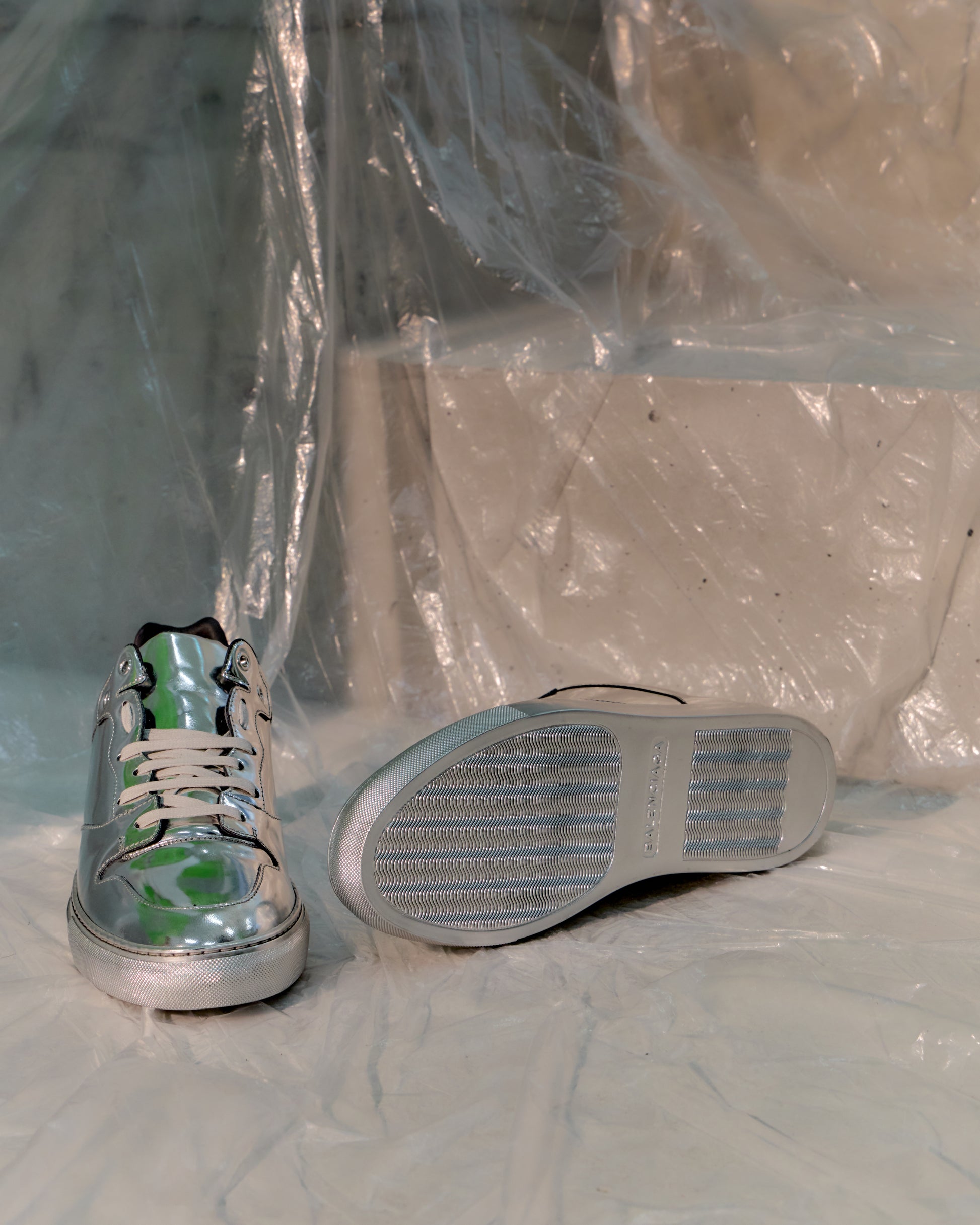 Silver Balenciaga sneaker with green accents on a white background