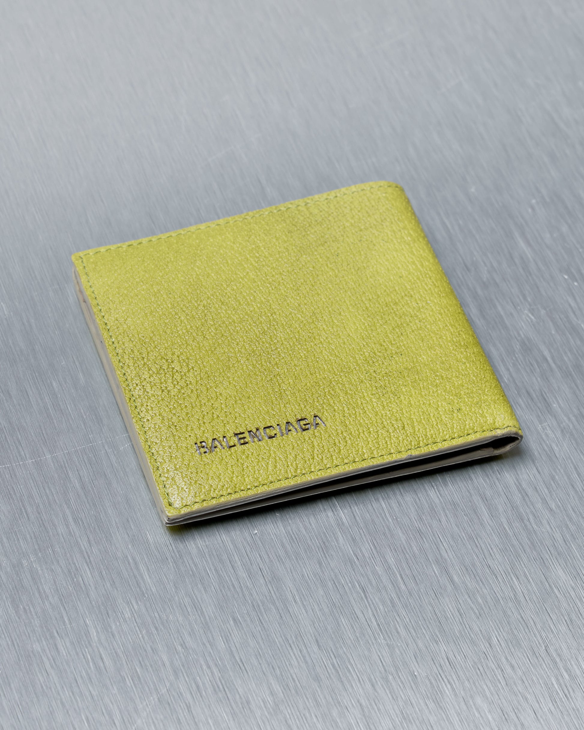 Yellow wallet with Balenciaga logo on a gray background