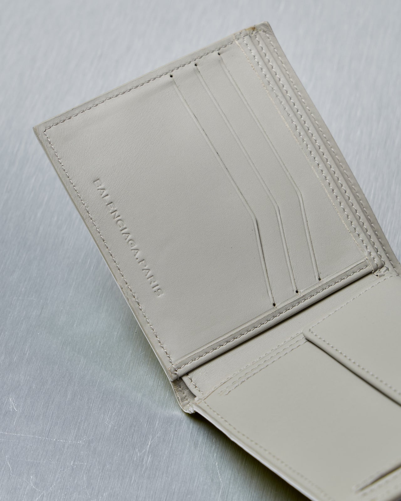 Yellow wallet with Balenciaga logo on a gray background