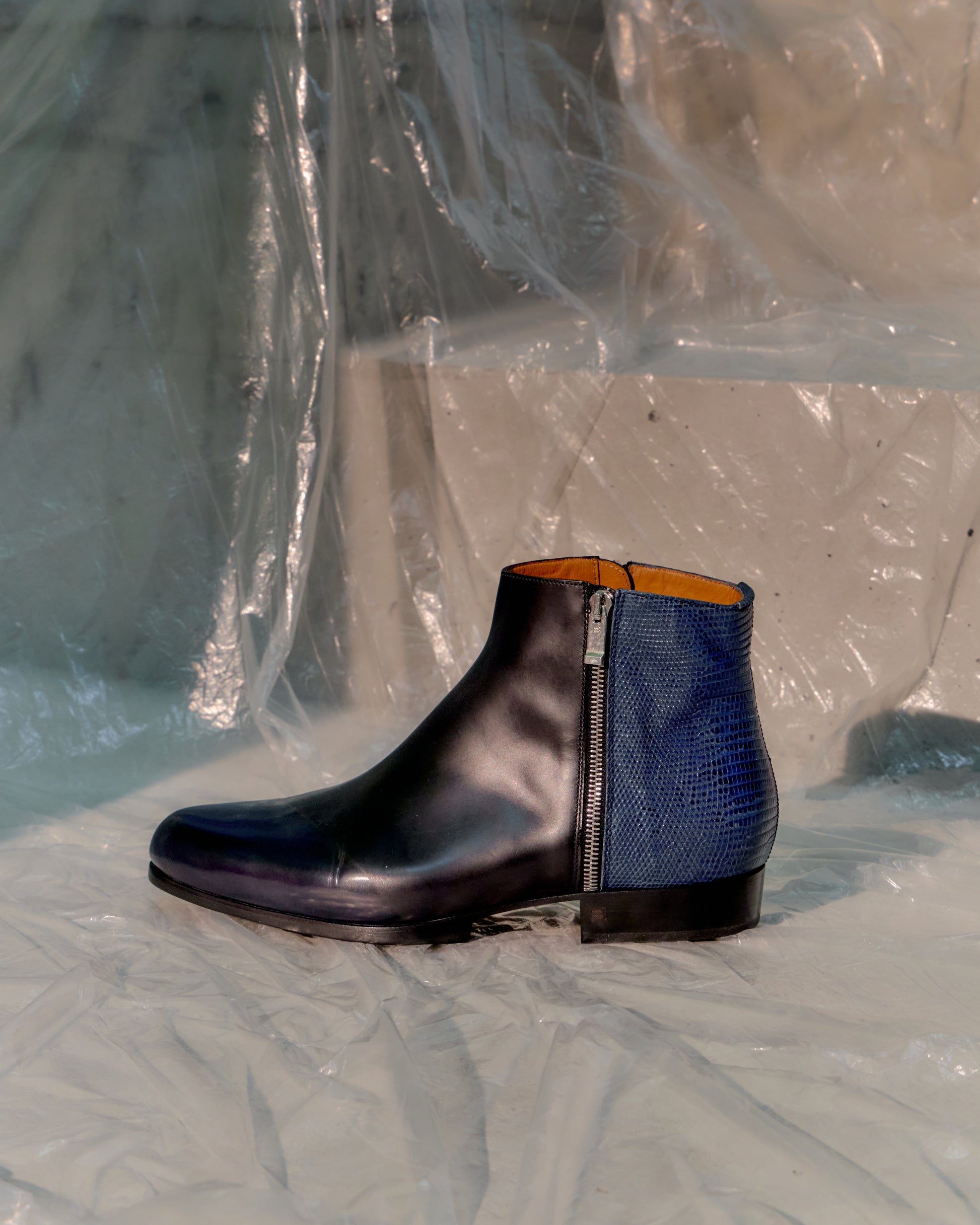Black leather Balenciaga boot with blue lining on a textured surface