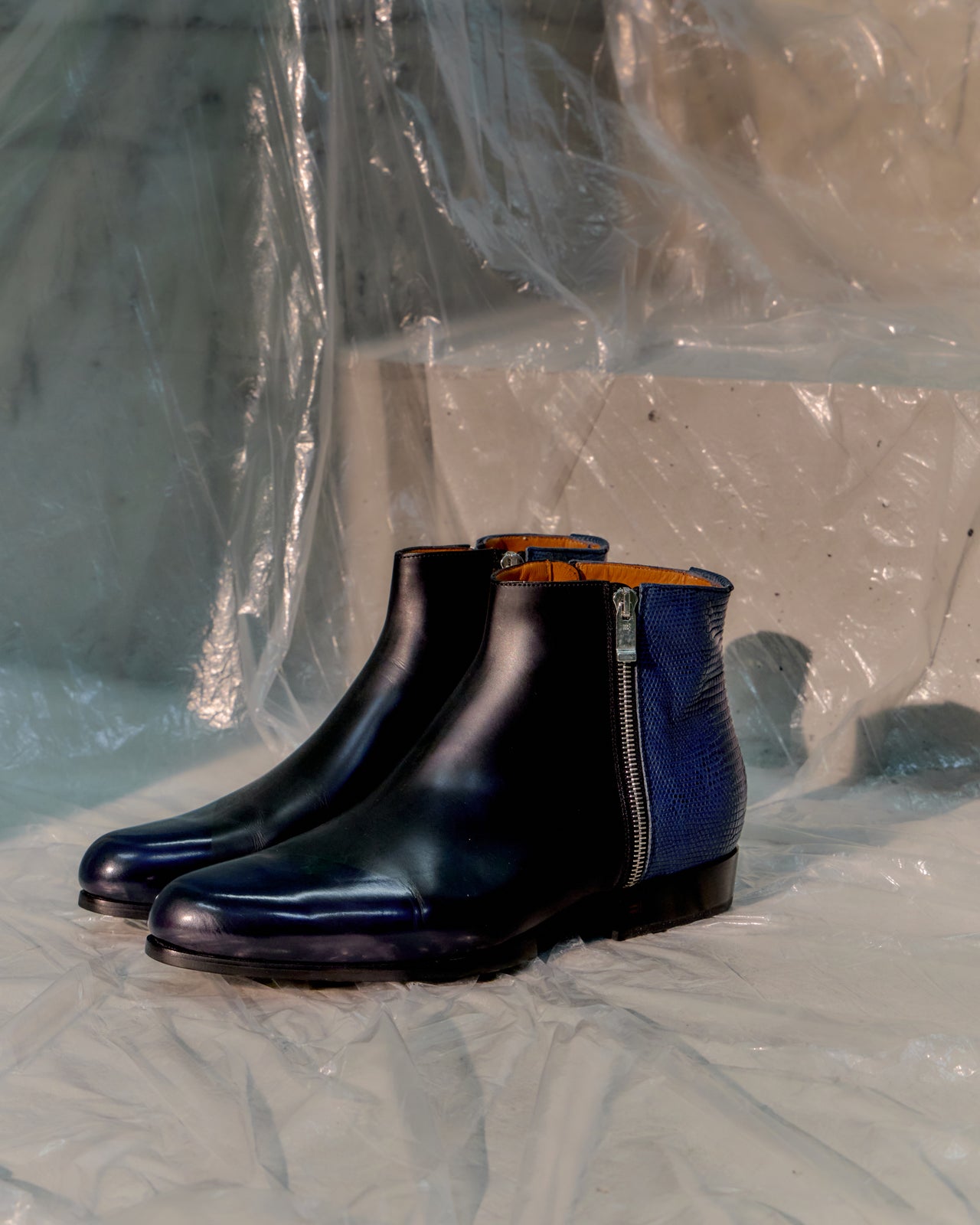 Black leather Balenciaga boot with blue lining on a textured surface