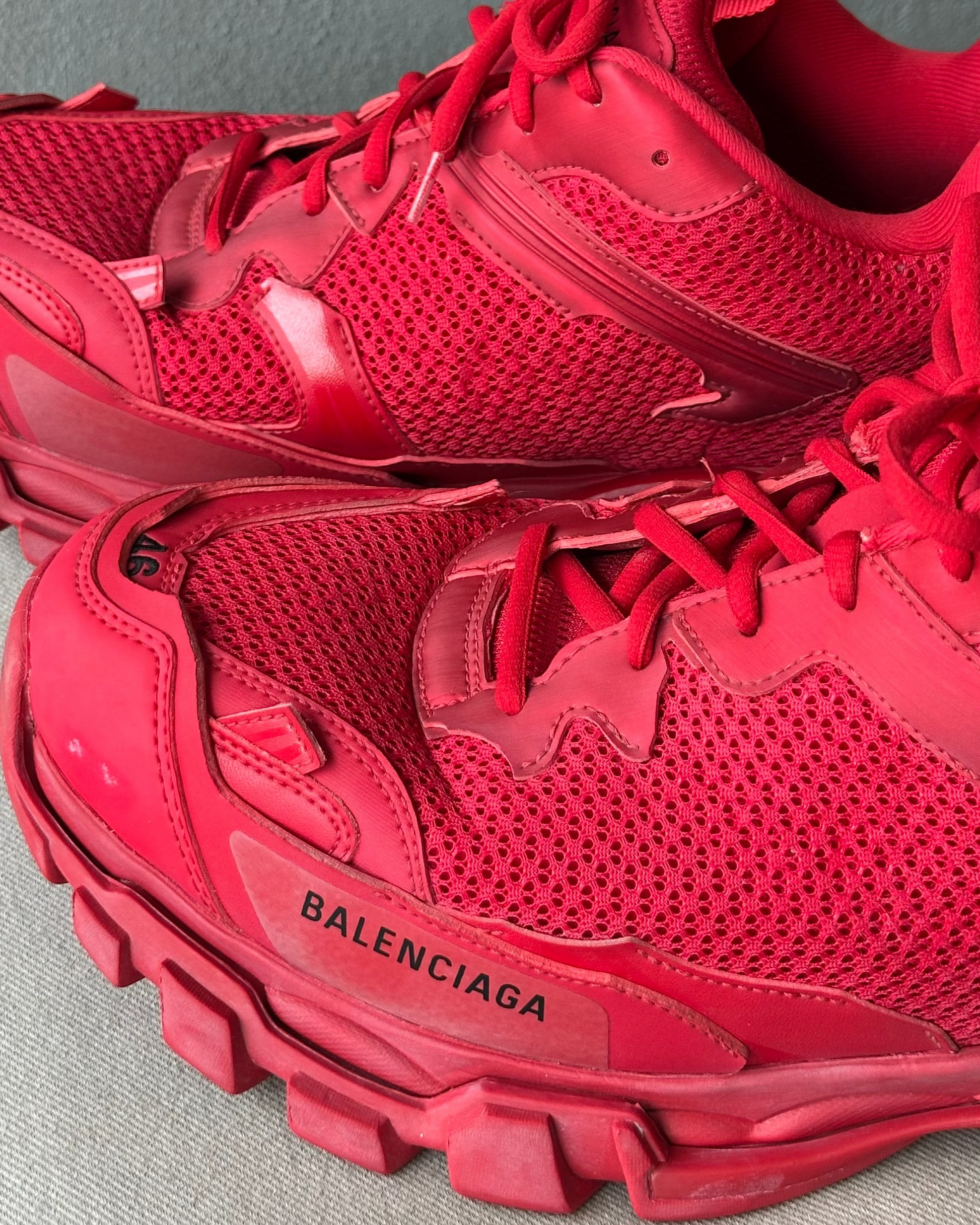 Red Balenciaga sneakers on a gray background