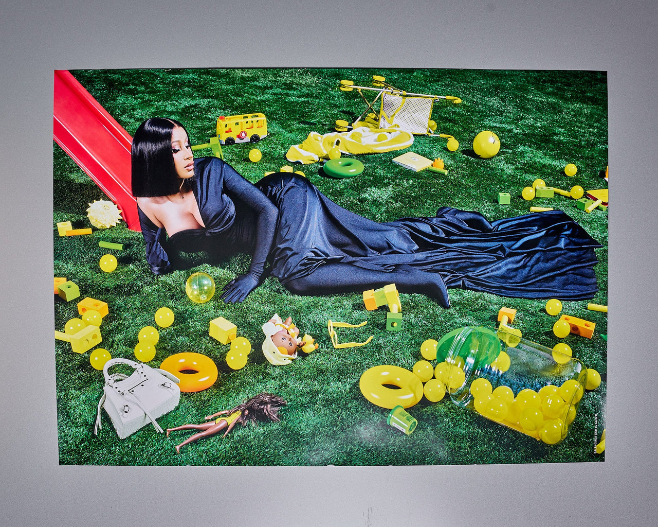 Limited edition poster featuring Cardi B with a green background, surrounded by Balenciaga-branded items and a red umbrella.