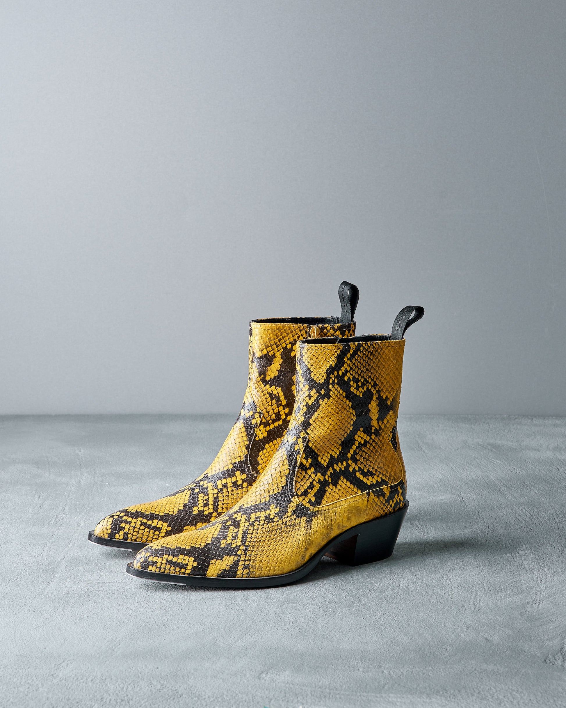 Yellow Bally snake print boots on a gray background