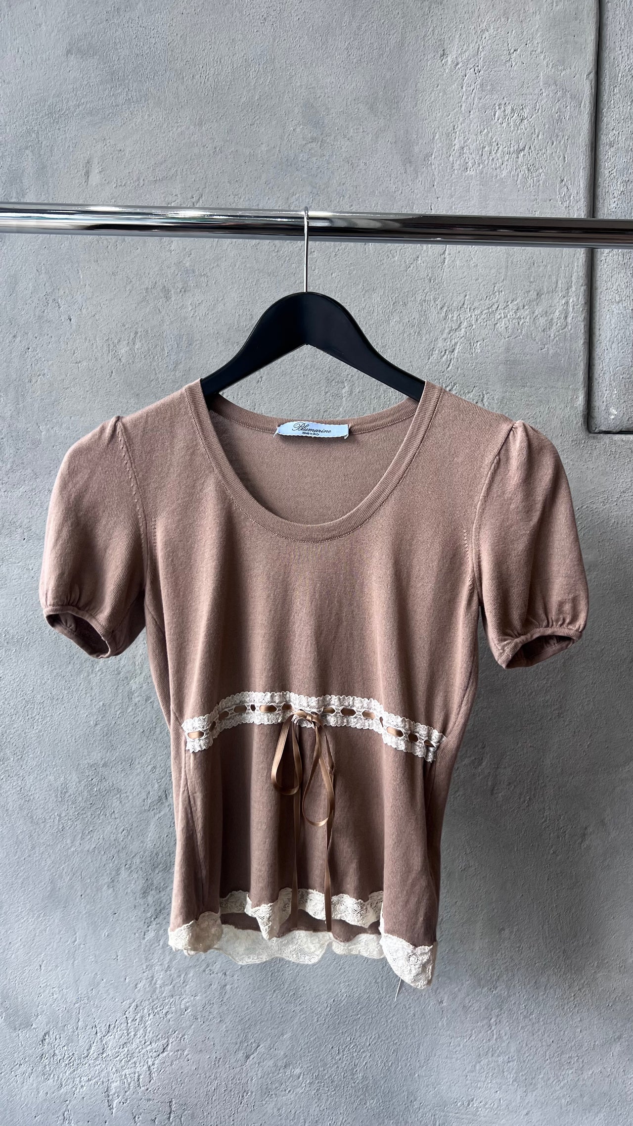 Brown Blumarine top with lace details on a textured surface