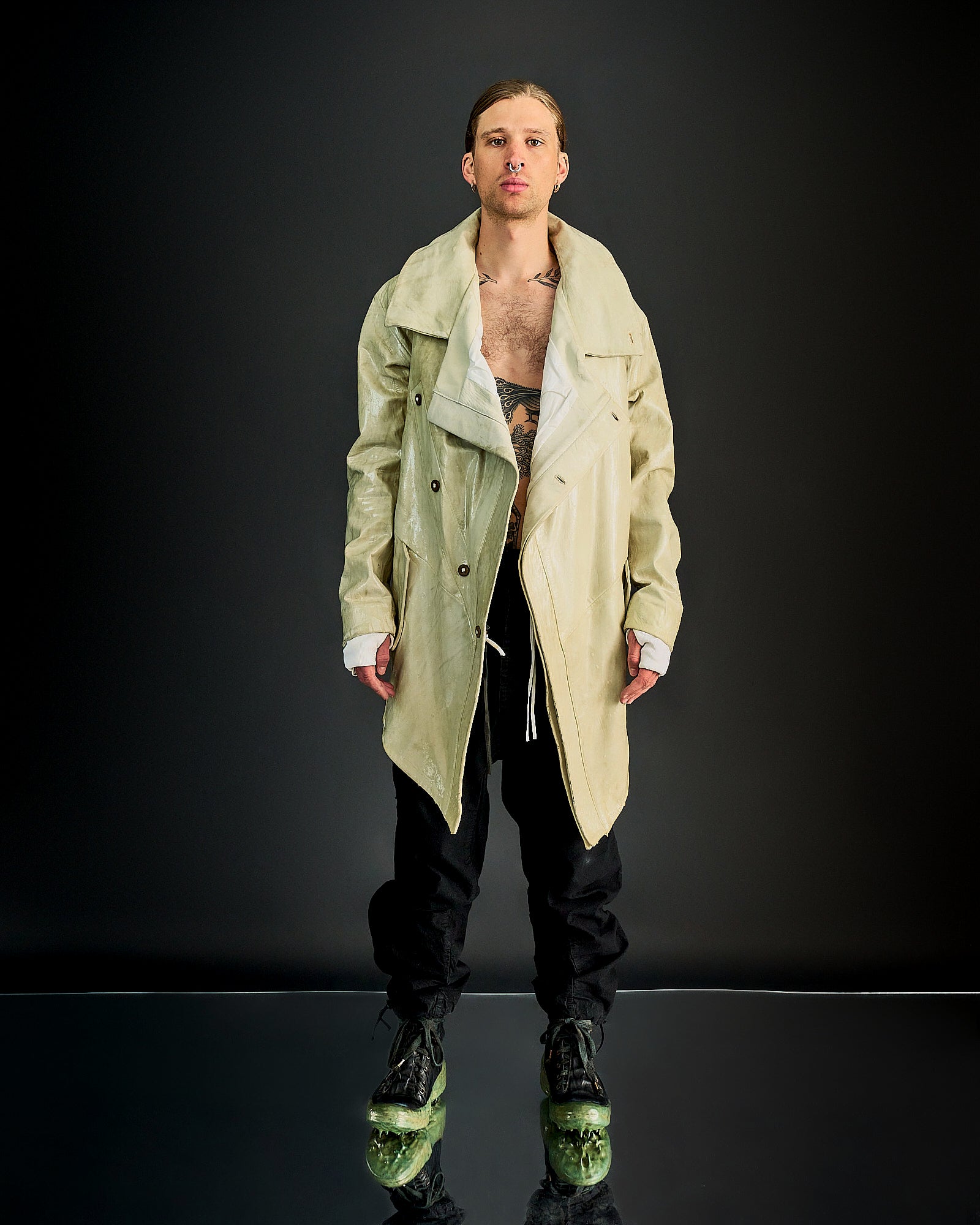 A person wearing an oversized double-breasted Boris Bidjan Saberi lamb leather jacket with raglan panels, exaggerated lapels, and a asymmetric four-button front.