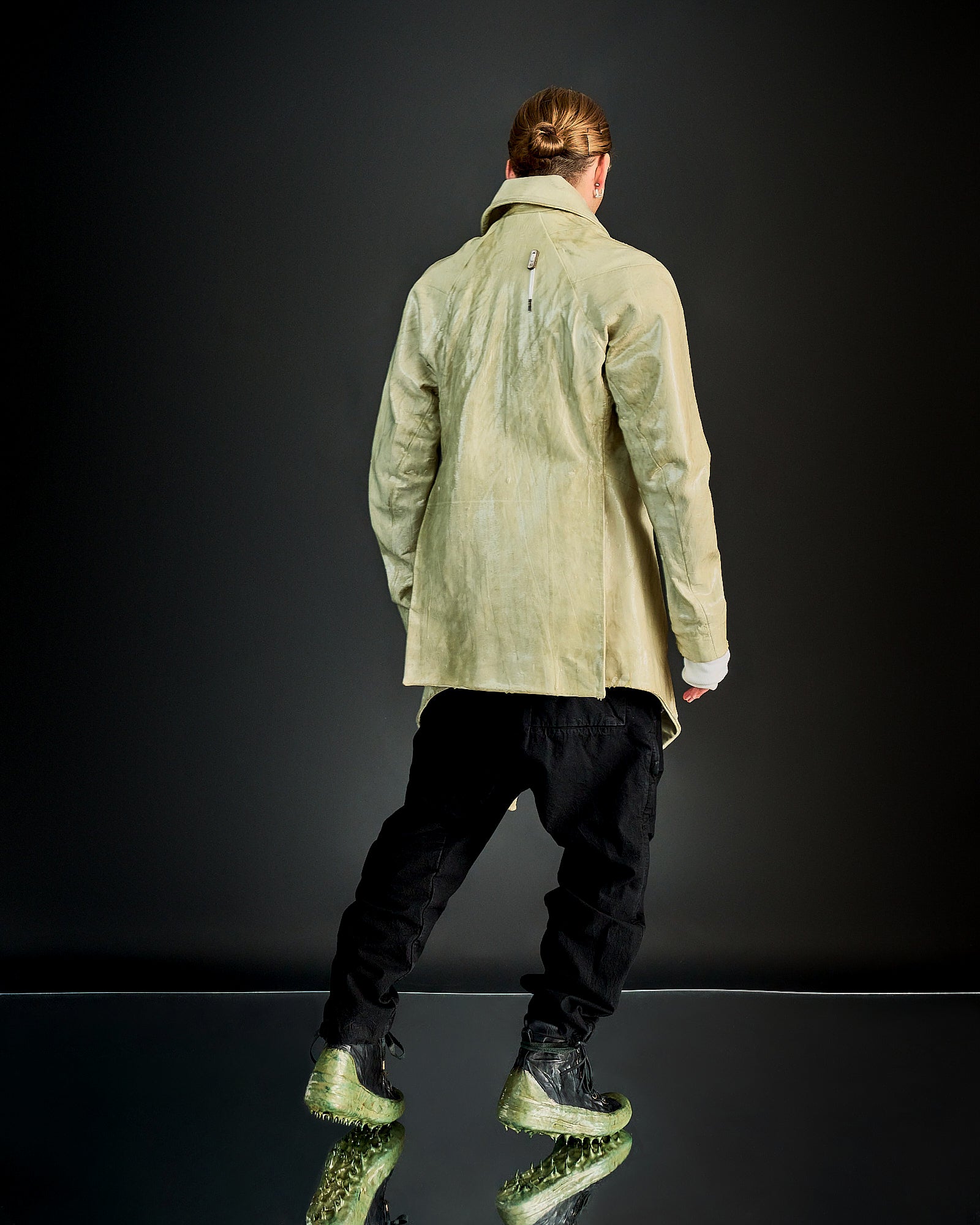 A person wearing an oversized double-breasted Boris Bidjan Saberi lamb leather jacket with raglan panels, exaggerated lapels, and a asymmetric four-button front.
