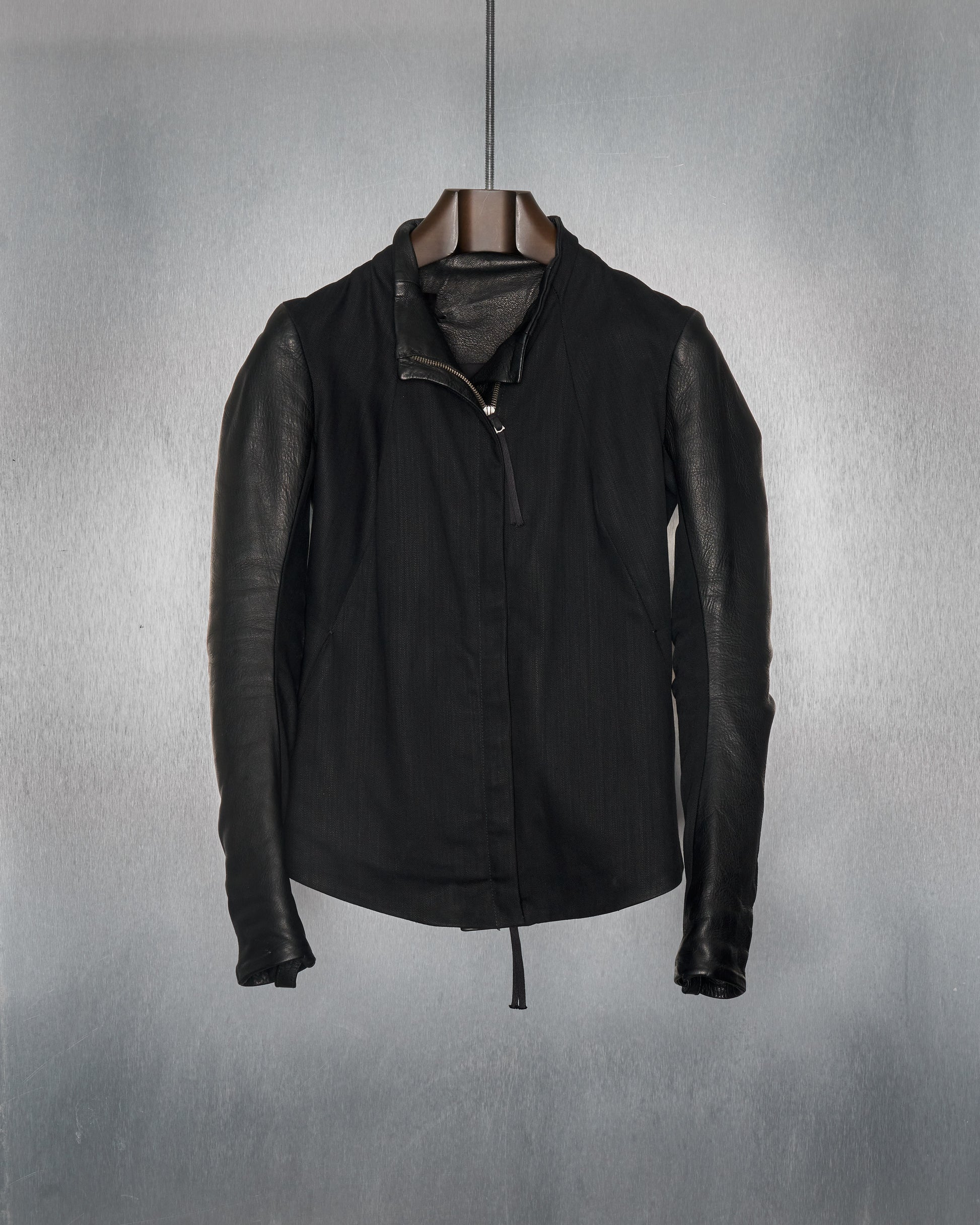A dual panelled leather Boris Bidjan Saberi  jacket with one side in black leather and the other in black cotton twill, featuring a double-zip front, two pockets, and a sterling silver aglet.