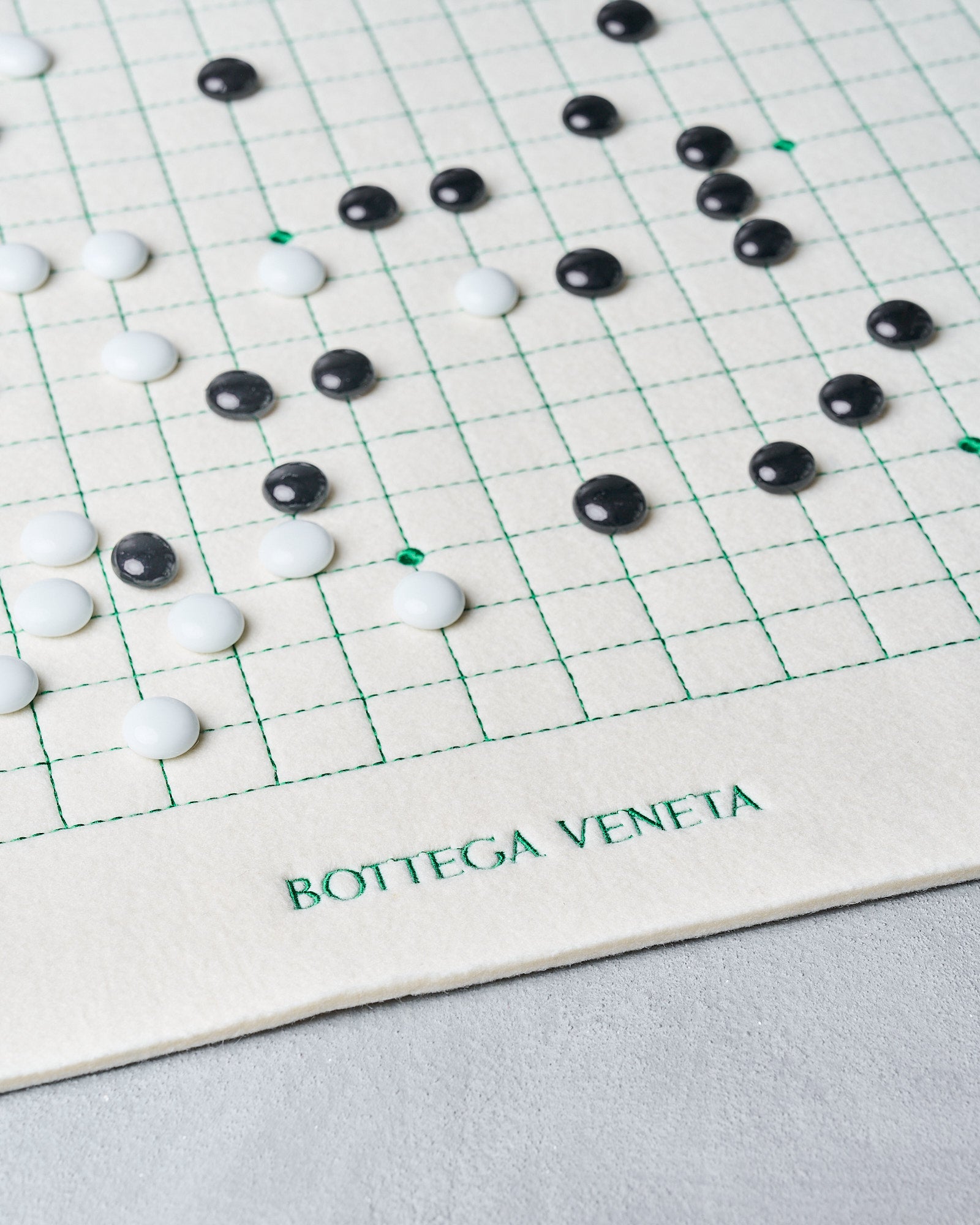 Close-up of a grid with black and white beads on a Bottega Veneta mat.
