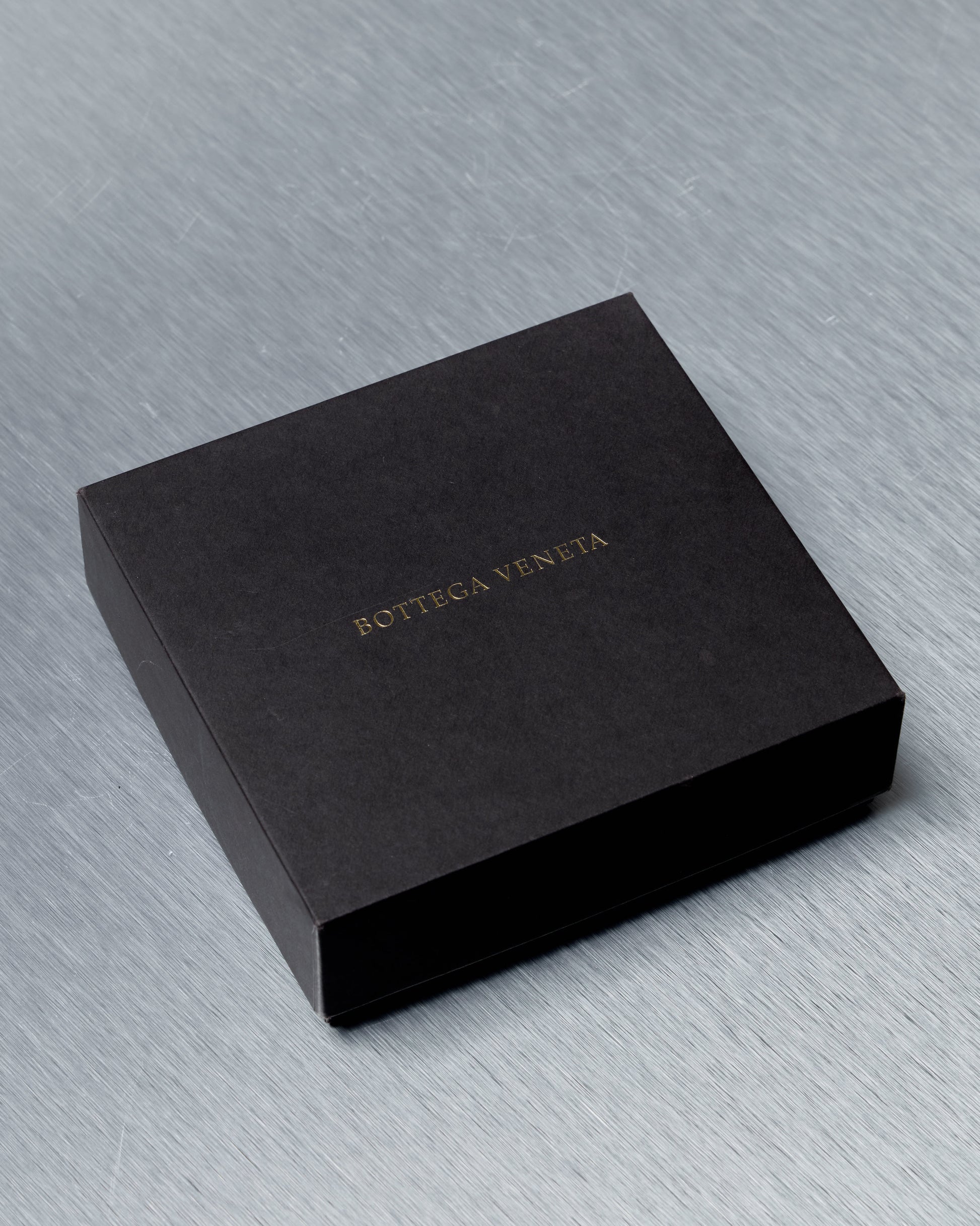 Black box with 'Bottega Veneta' branding on a gray surface