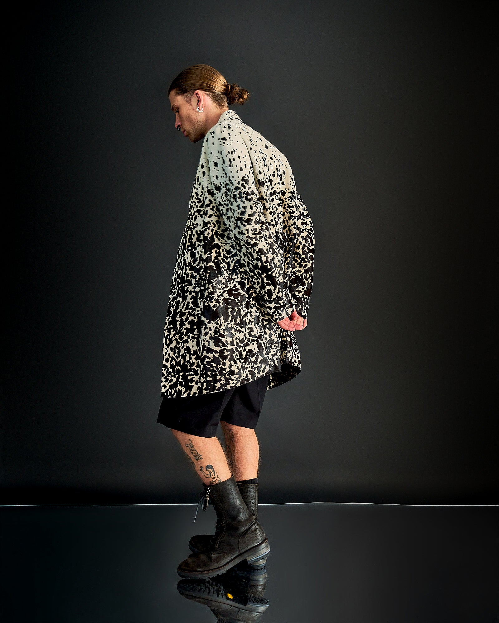 A person wearing a Burberry branded leather coat with a speckled animal print, featuring a four-button front and notch lapel.