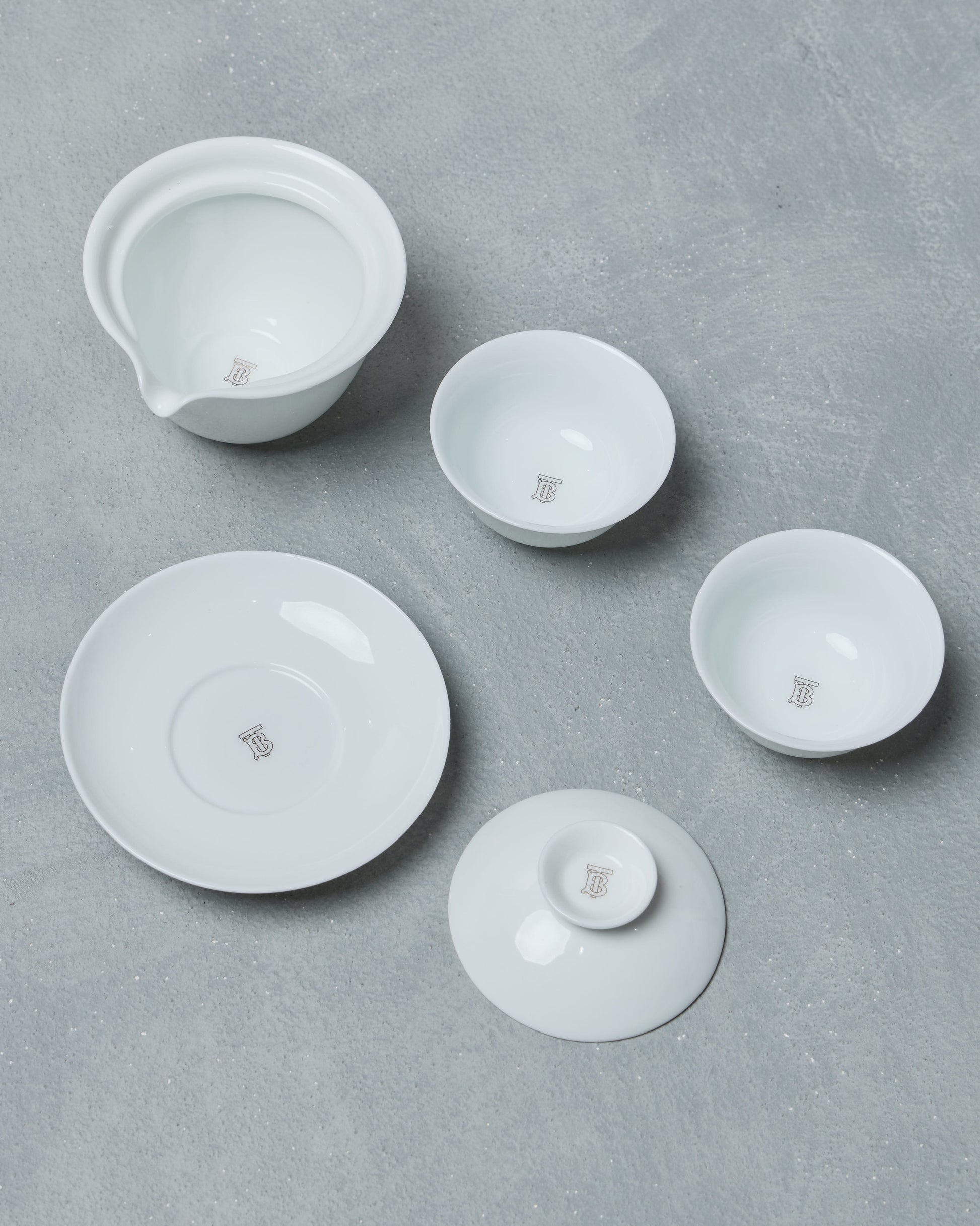Set of white ceramic Burberry bowls on a gray surface