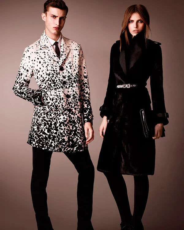 Two people wearing stylish Burberry coats against a plain background