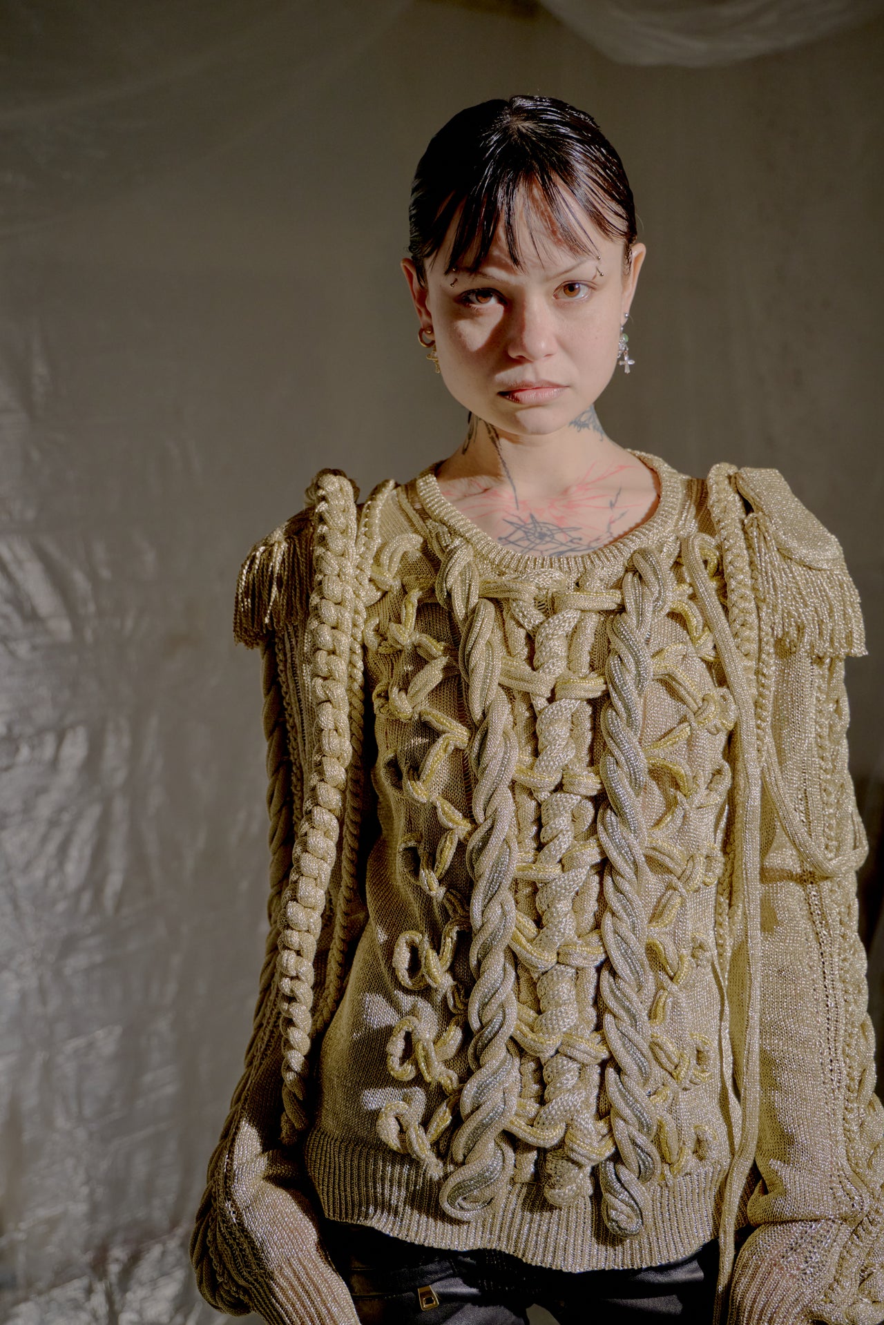 Person wearing a textured gold Burberry sweater against a neutral background