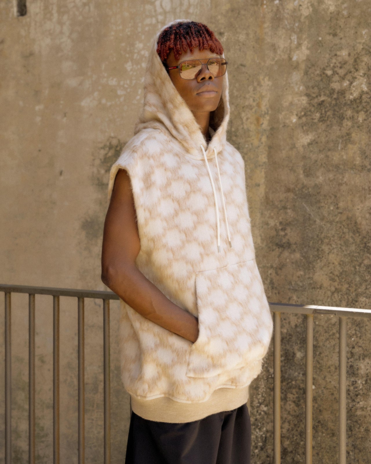 A person wearing a Celine brand hoodie with a geometric pattern, featuring a hood and large front pocket.