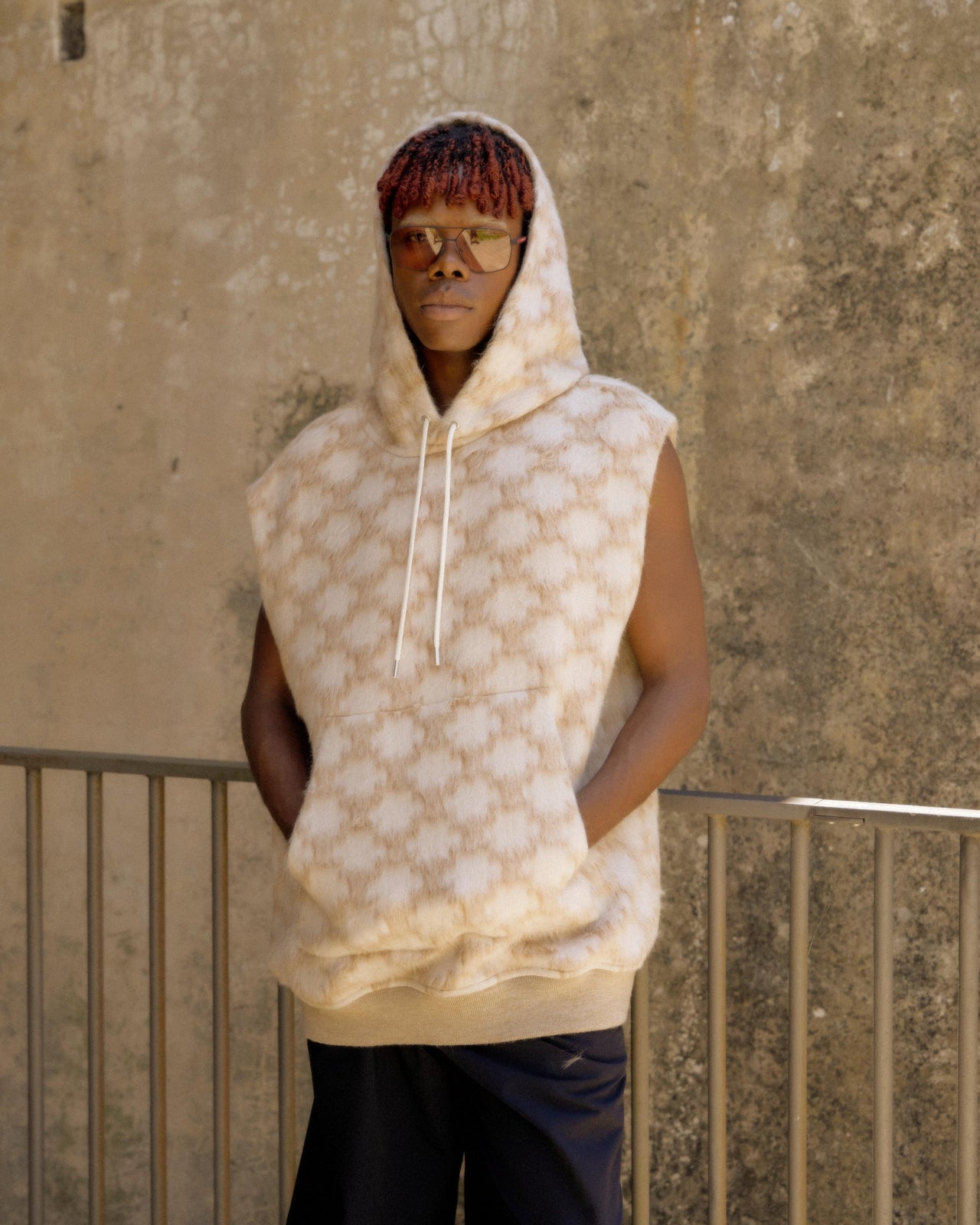 A person wearing a Celine brand hoodie with a geometric pattern, featuring a hood and large front pocket.