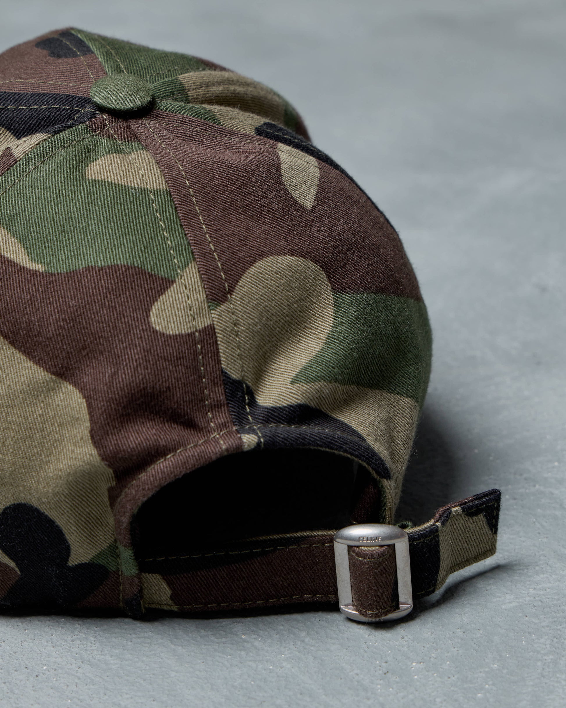 Camouflage Celine baseball cap with a buckle on a gray background