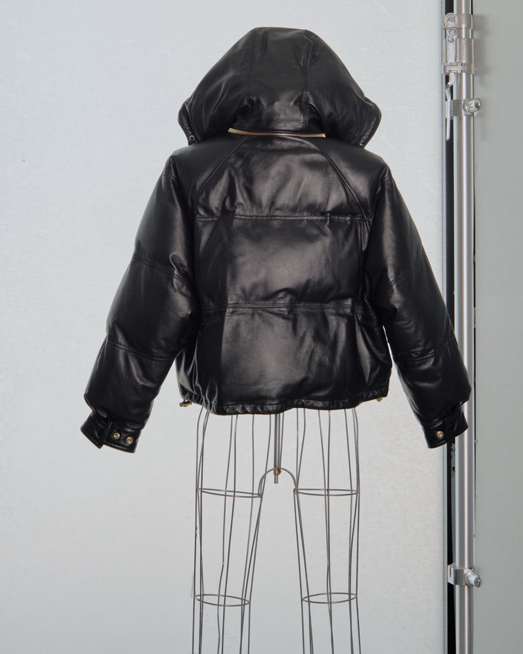 Black leather Celine jacket on a mannequin against a plain background