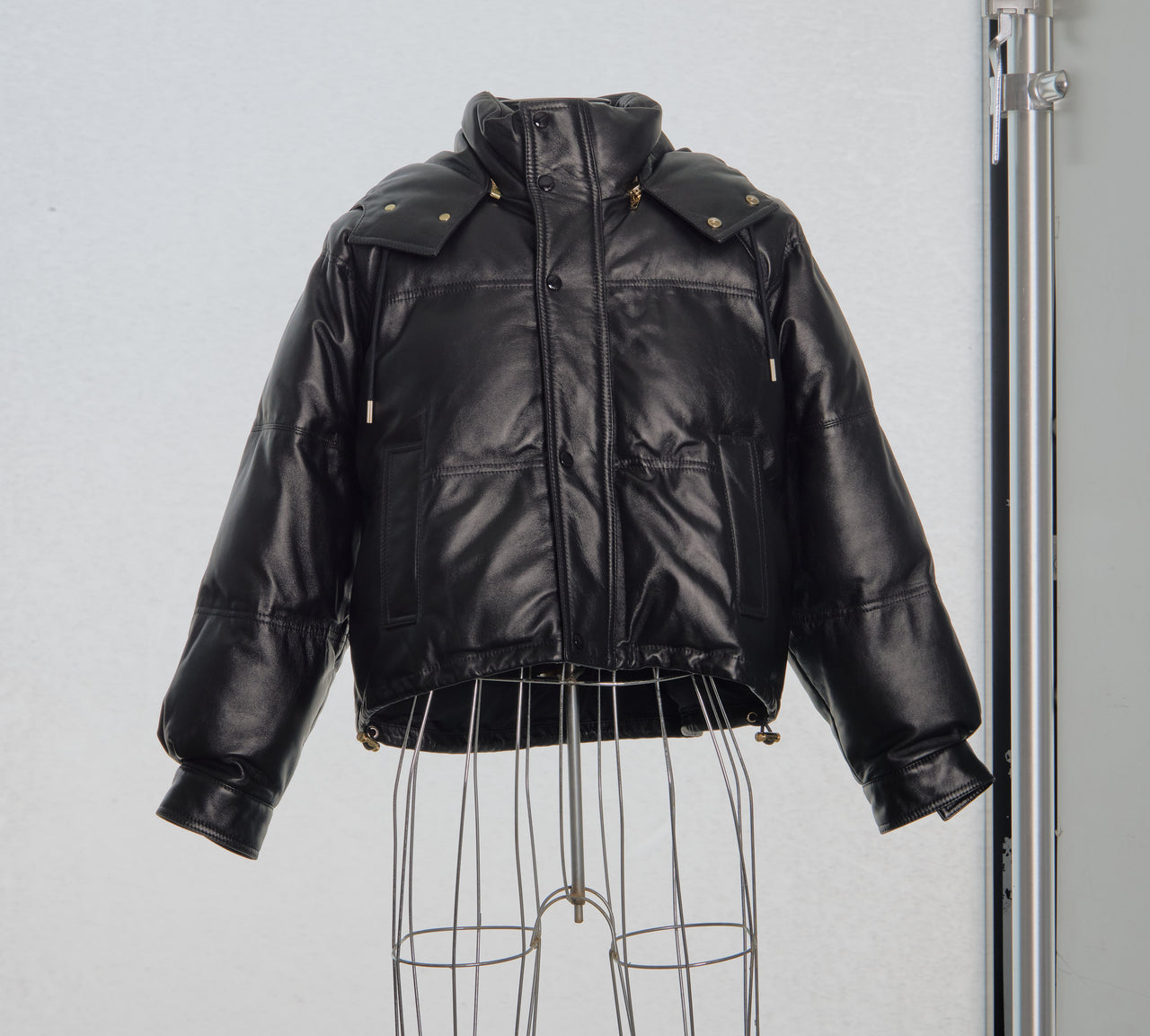 Black leather Celine jacket on a mannequin against a plain background