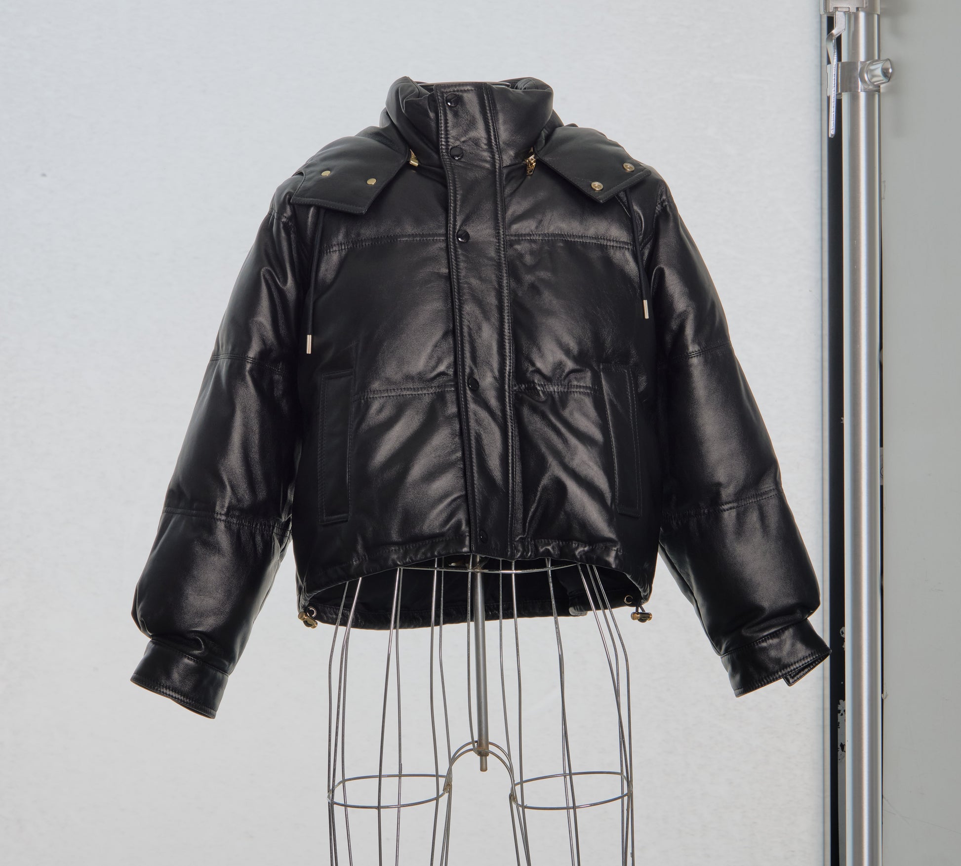 Black leather Celine jacket on a mannequin against a plain background