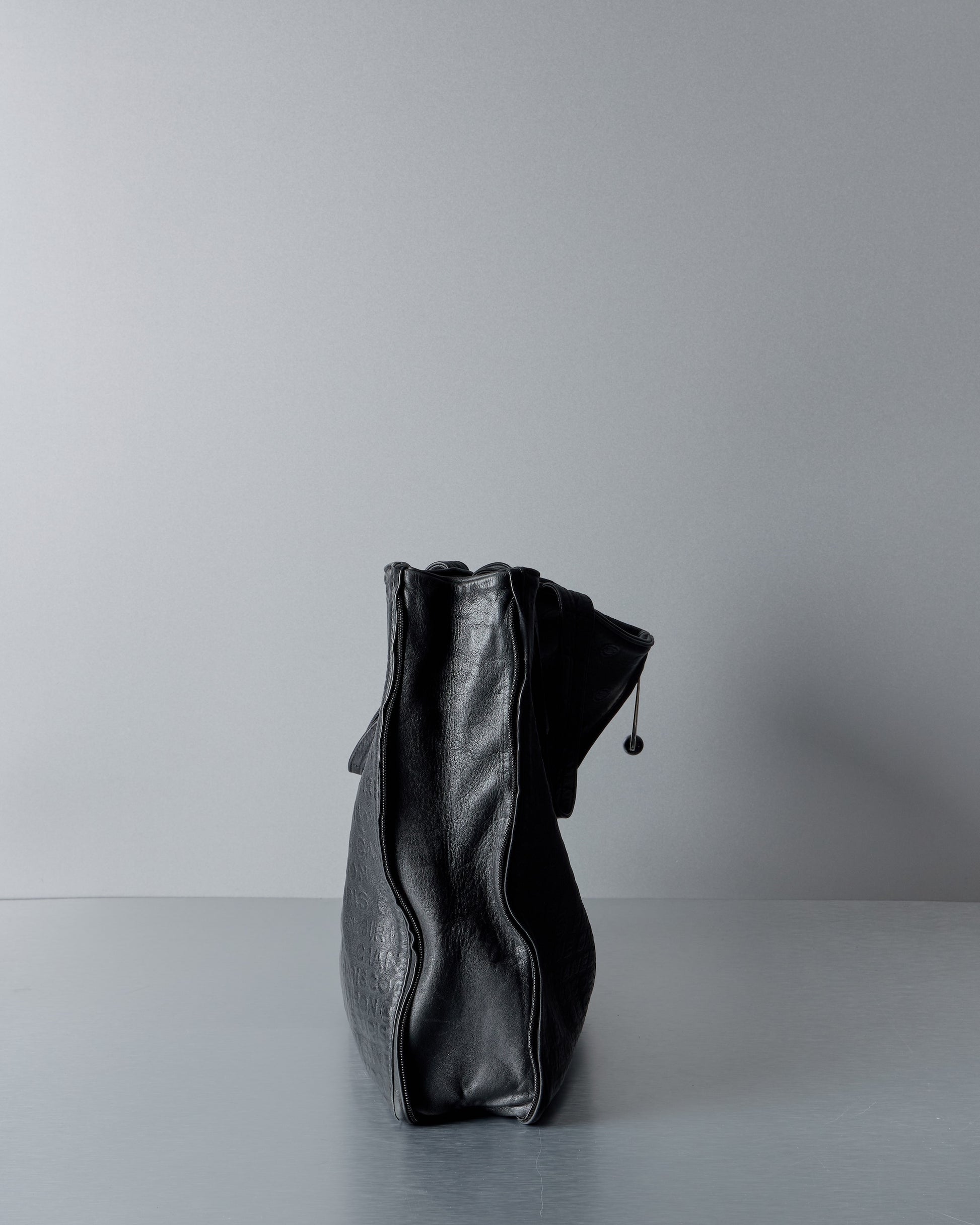 Black leather Chanel handbag on a light gray background
