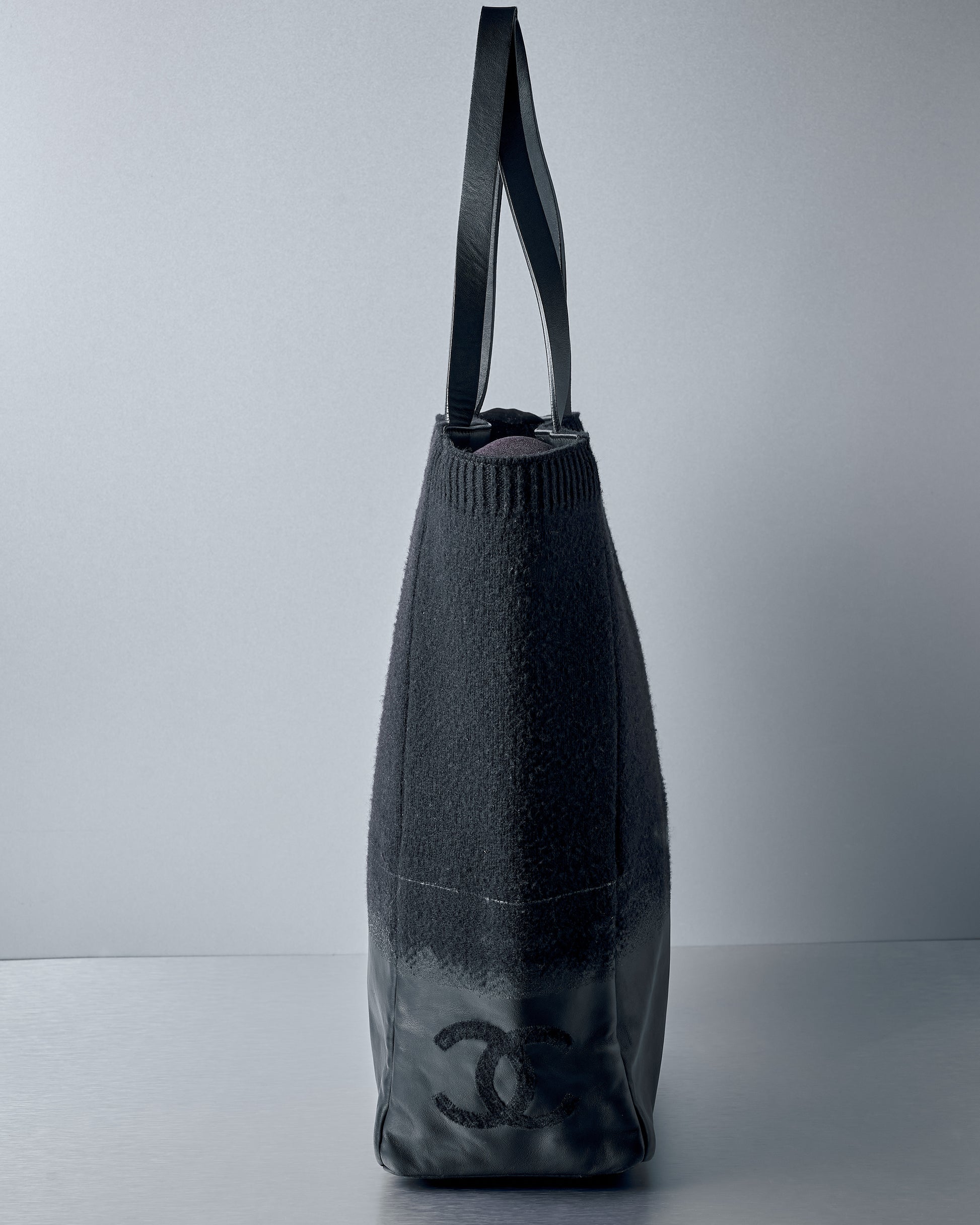 Black Chanel handbag on a grey background