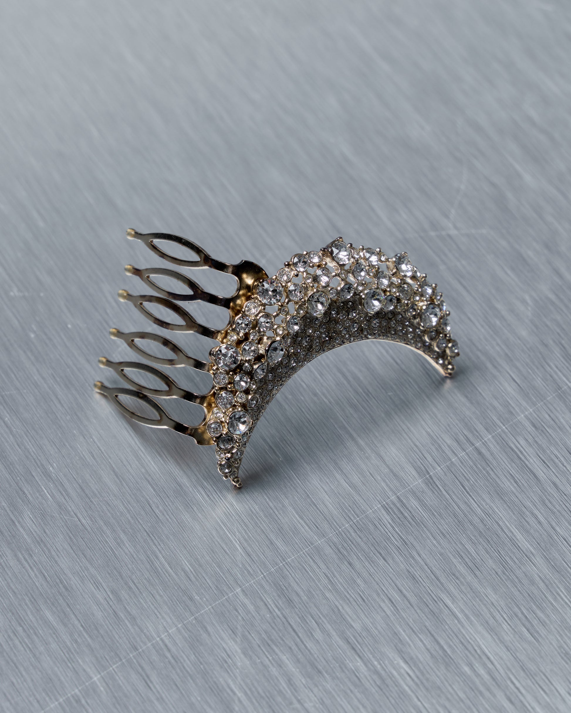 Decorative Chanel half moon hair comb with rhinestones on a metallic surface