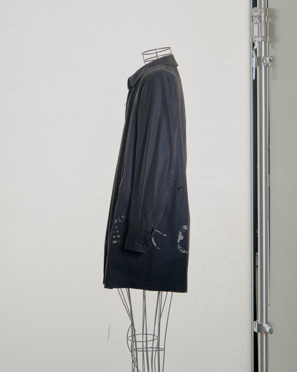 Black Comme des Garcons car coat on a mannequin against a white background