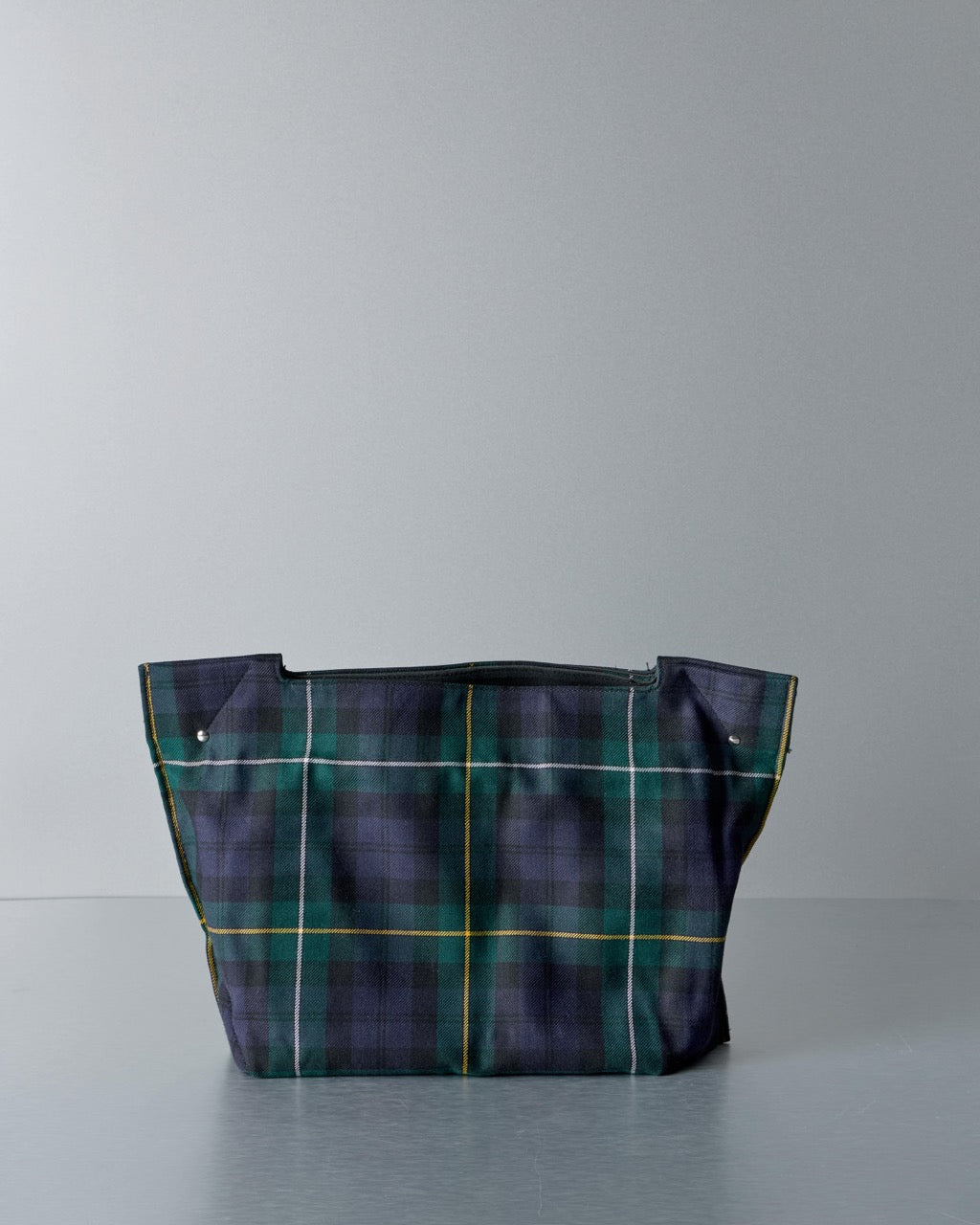 Plaid Comme des Garcons bag on a gray background