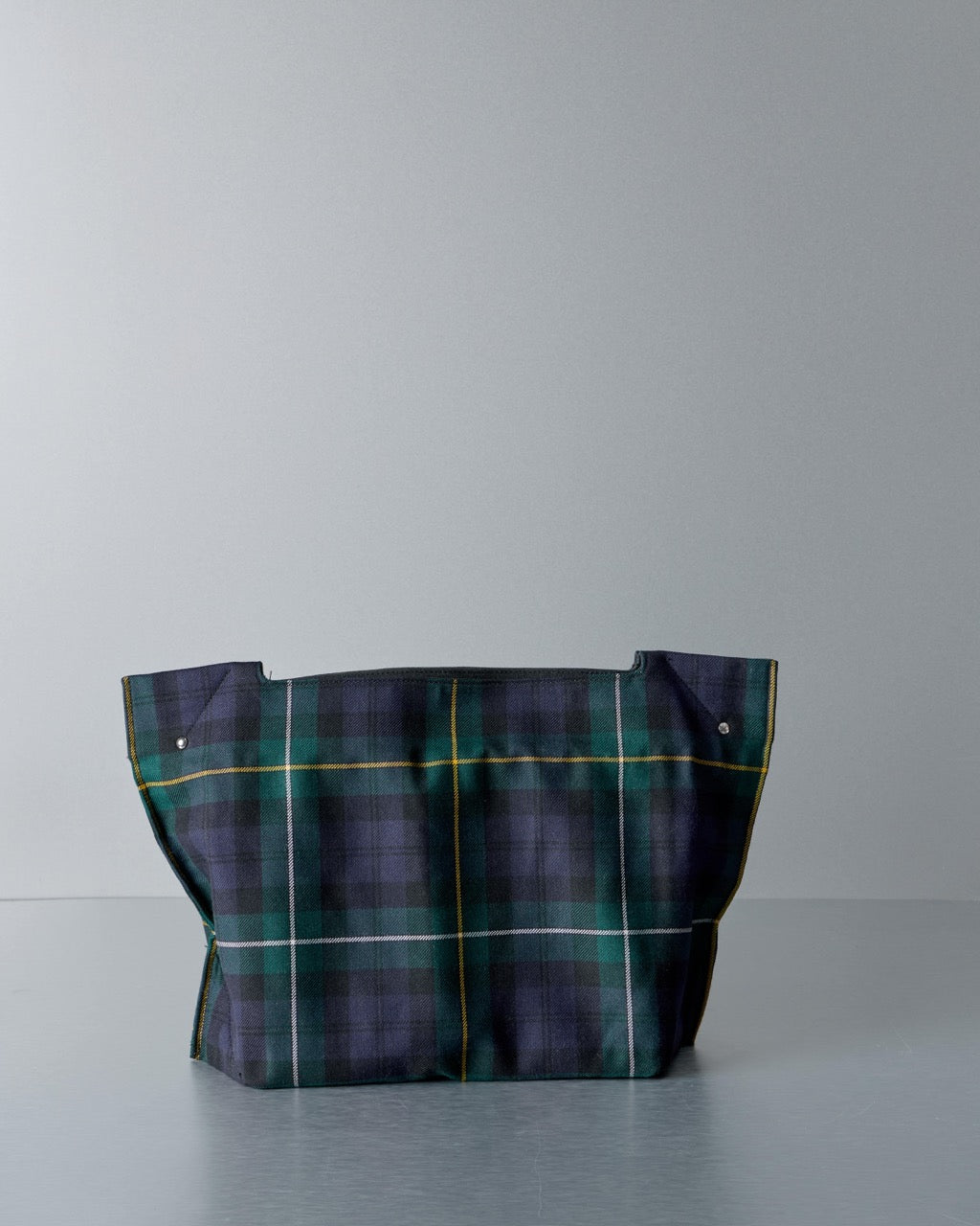 Plaid Comme des Garcons bag on a gray background