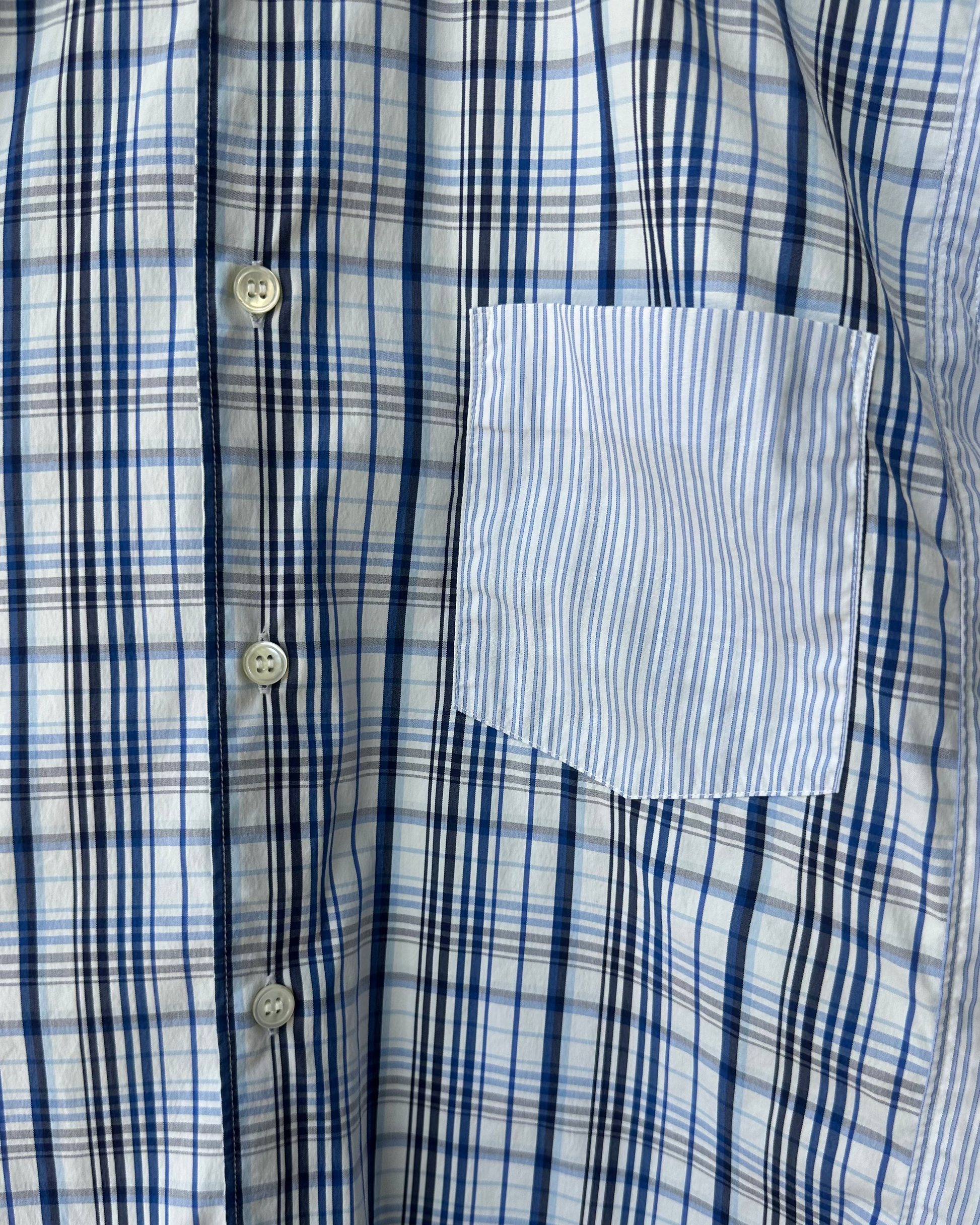 Close-up of a blue and white checkered Comme des Garcons shirt with a pocket