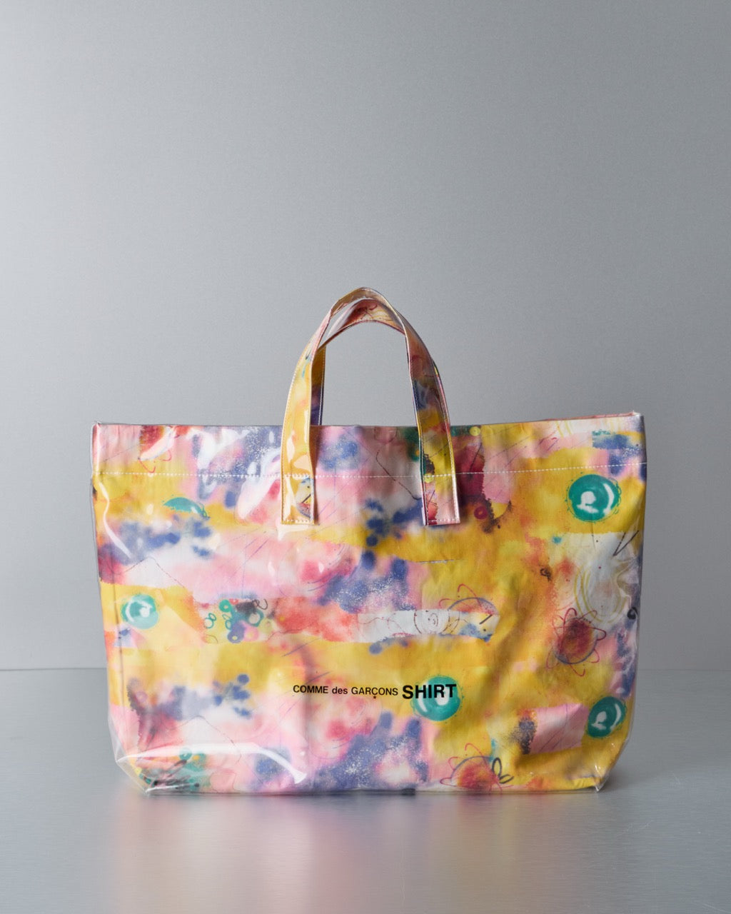 Colourful Comme des Garcons SHIRT x Futura Laboratories tote bag with floral pattern on a gray background