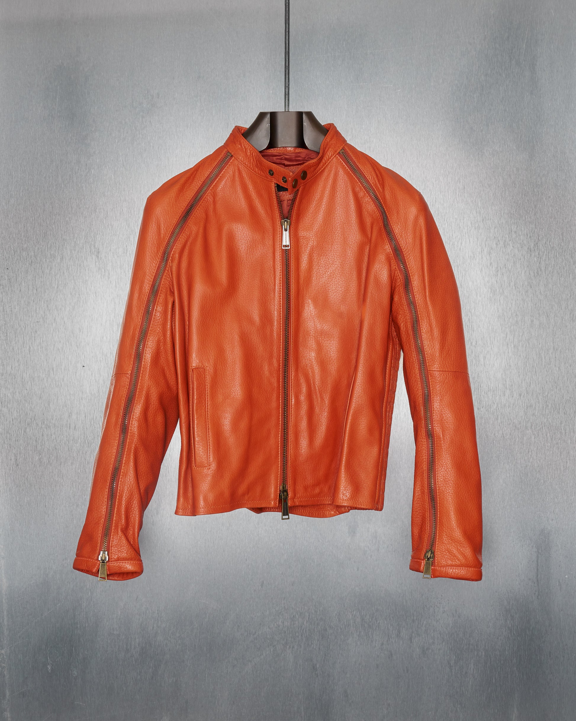 A DSquared2 branded orange leather moto jacket with raglan zips on the arms, a double-zip front, and ribbed waist.