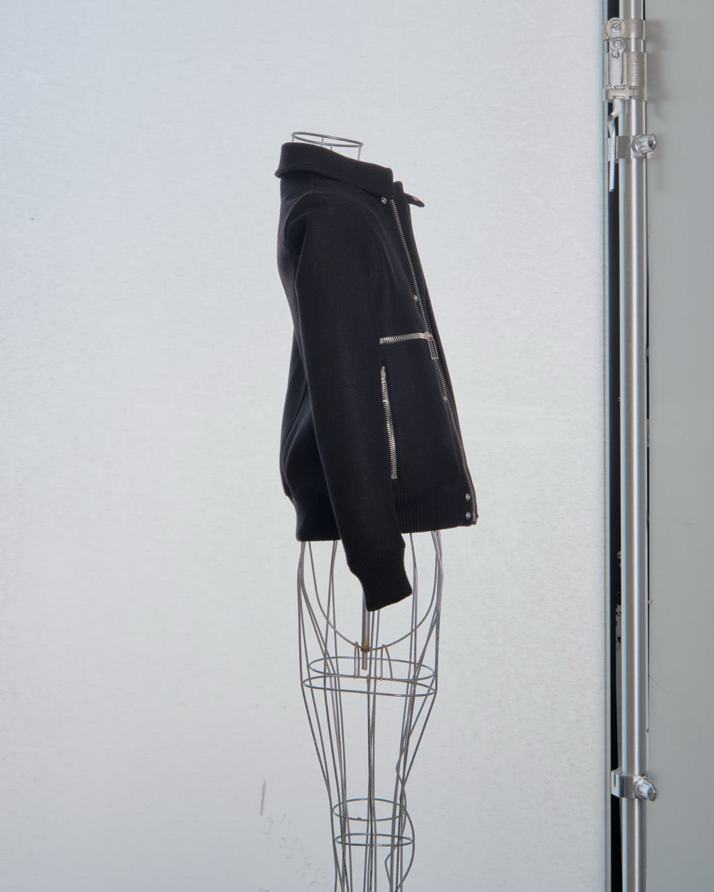 Black Dior jacket on a wire mannequin against a white background