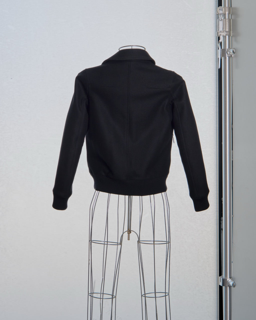 Black Dior jacket on a mannequin against a white background
