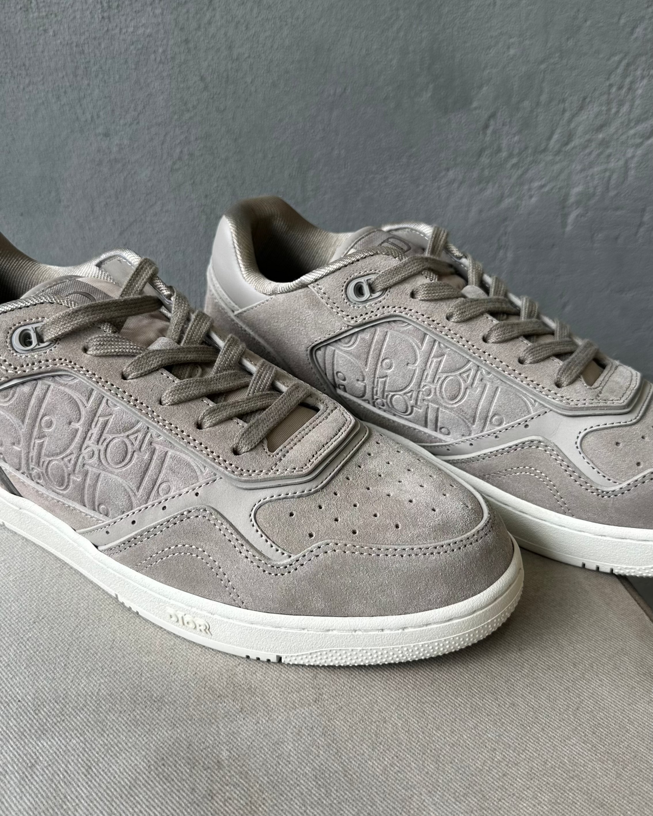 Gray Dior sneaker on a textured gray surface