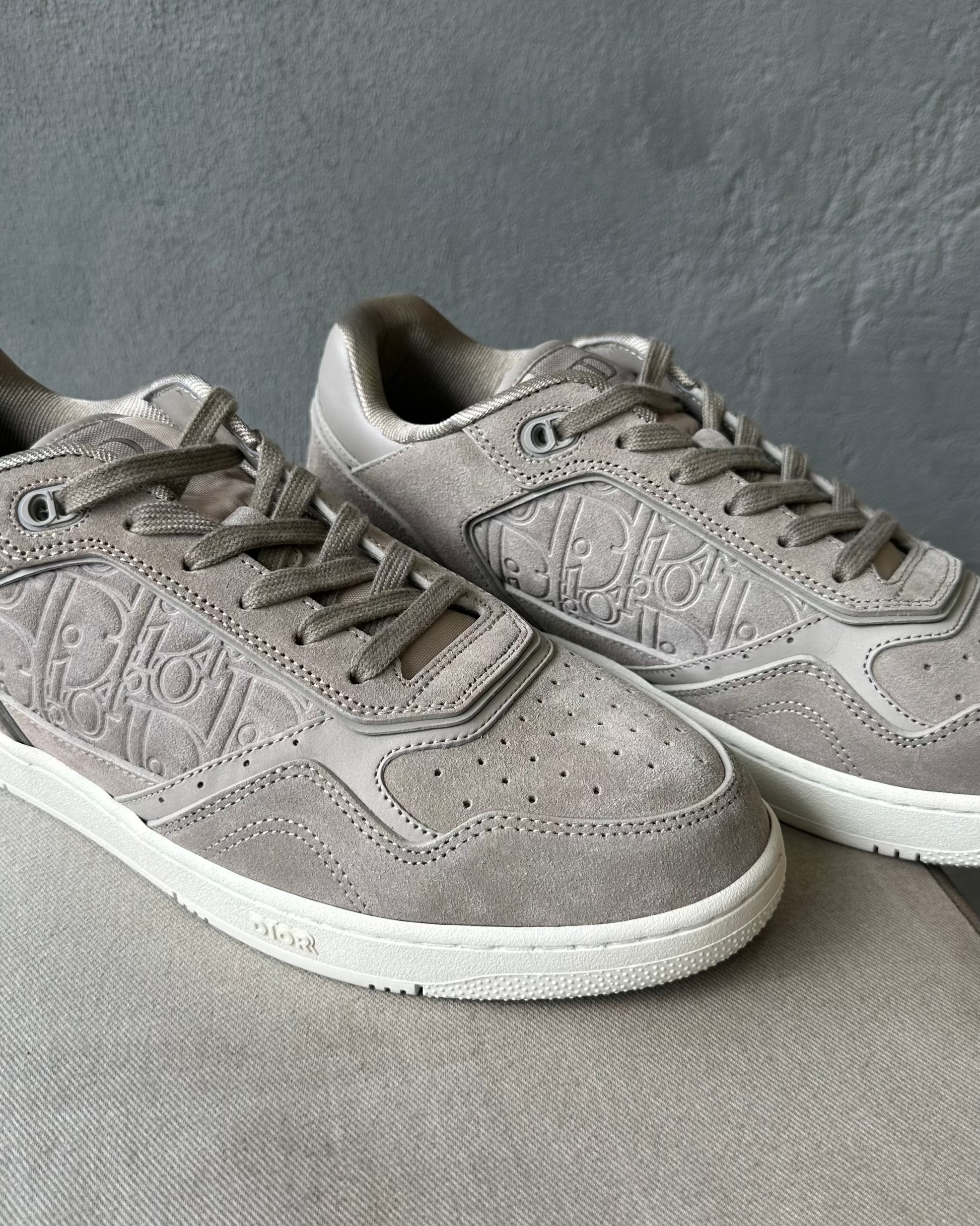Pair of gray Dior sneakers on a gray background