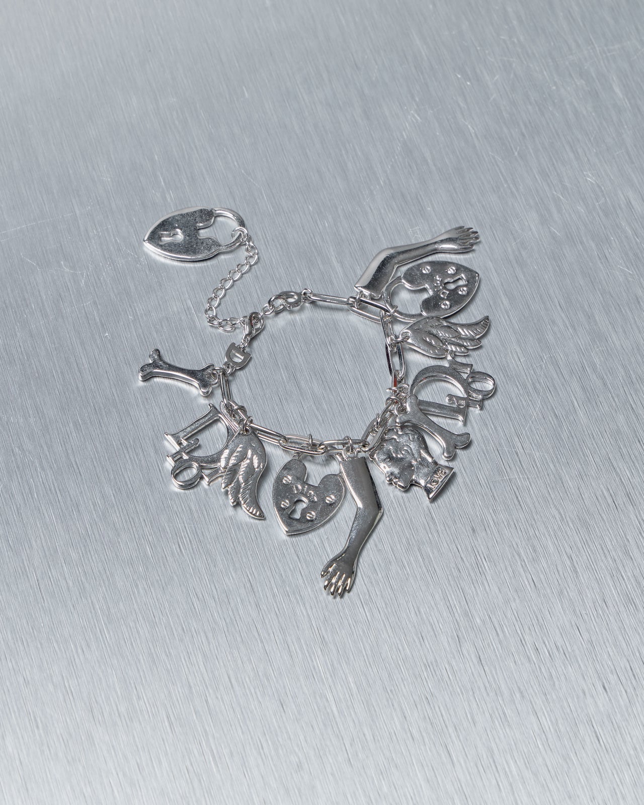 Silver Dior charm bracelet on a metallic surface