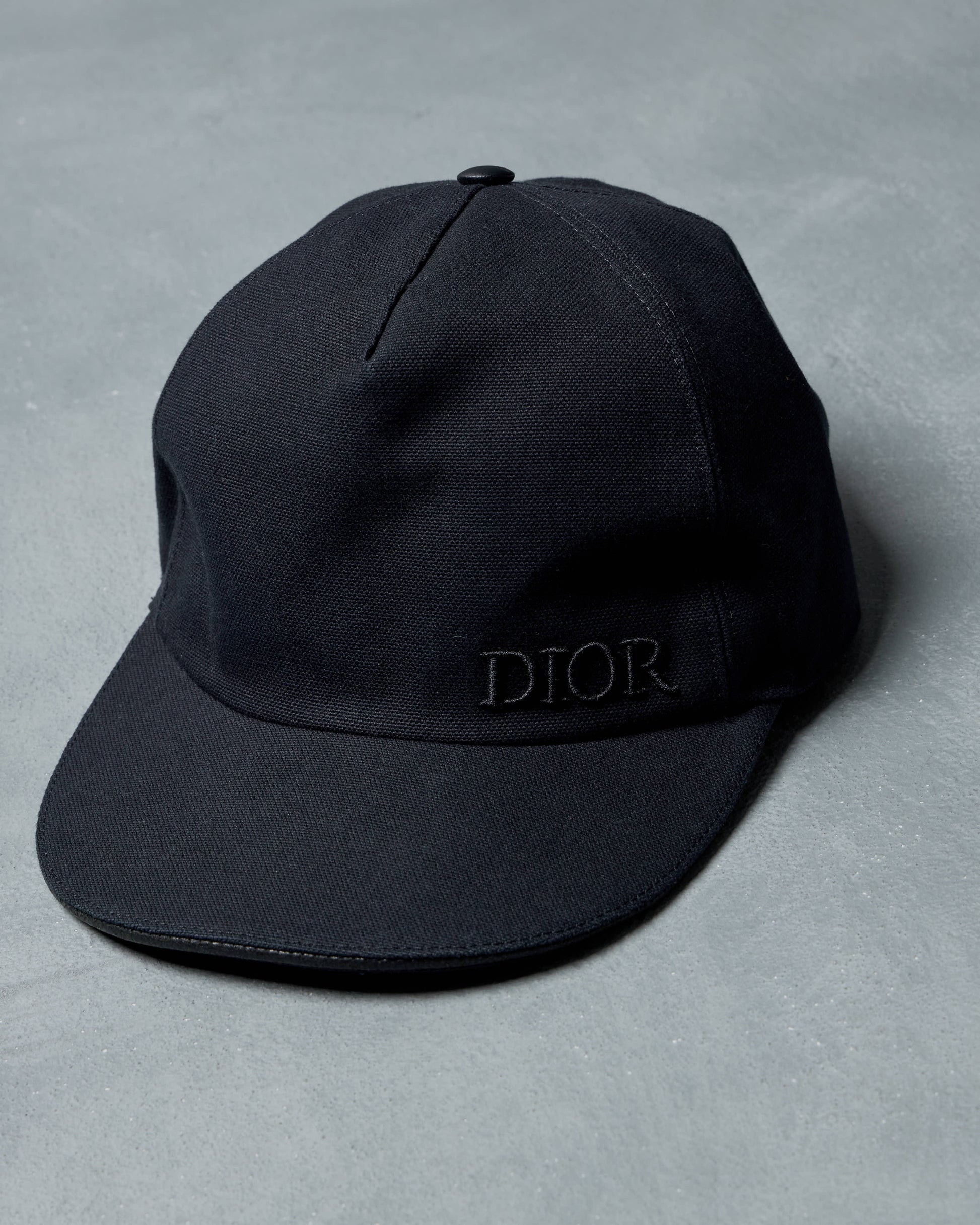 Black cap with 'Dior' logo on a gray background