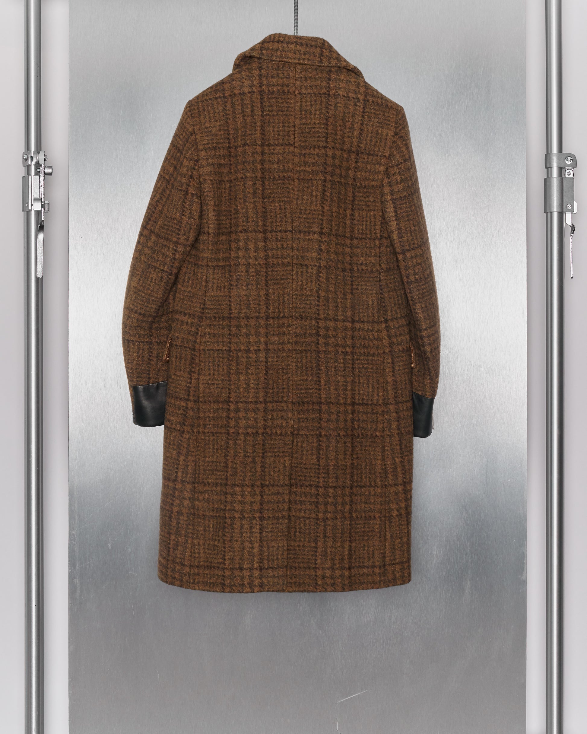 Brown plaid Dries Van Noten coat with dark cuffs, viewed from the back against a silver background. The coat has a classic, sophisticated design.