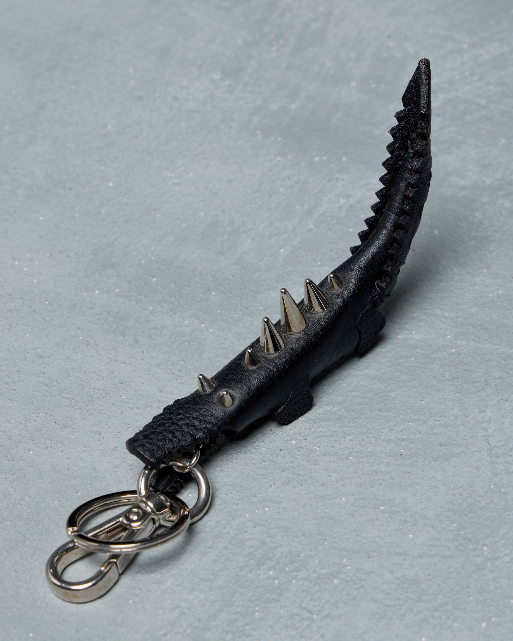 Black Fendi spiked keychain on a gray background