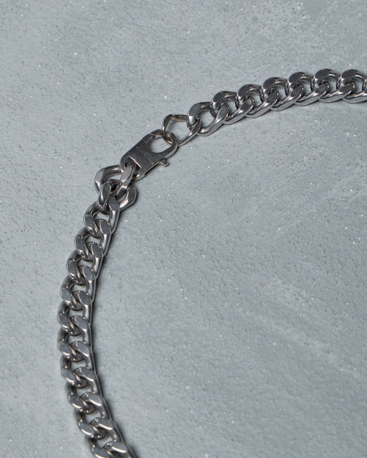 Silver chain Fendi necklace with a yellow tag on a gray background