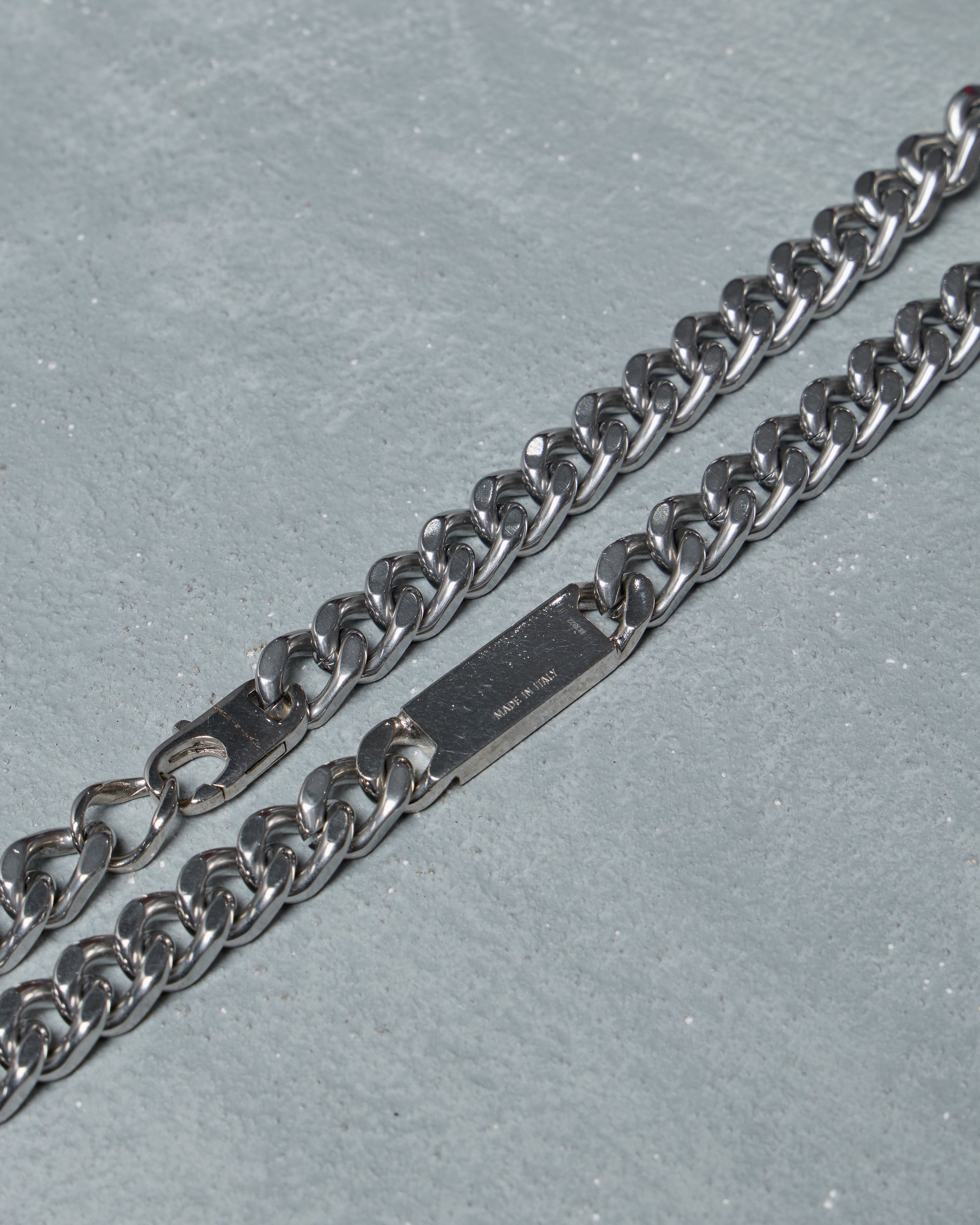 Silver chain Fendi necklace on a gray surface