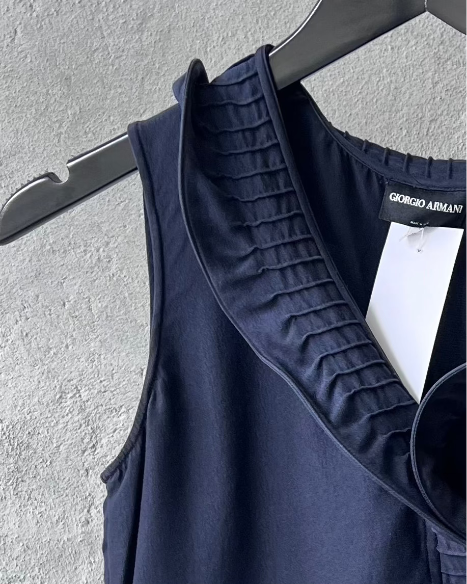 Navy blue Giorgio Armani tank top on a hanger against a gray wall
