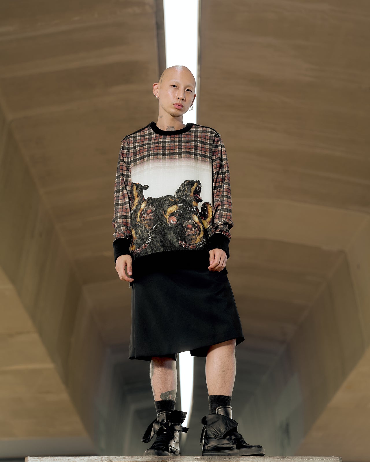 A model wearing a Givenchy AW 2011 sweatshirt with a Rottweiler side-zip design in a tartan print.