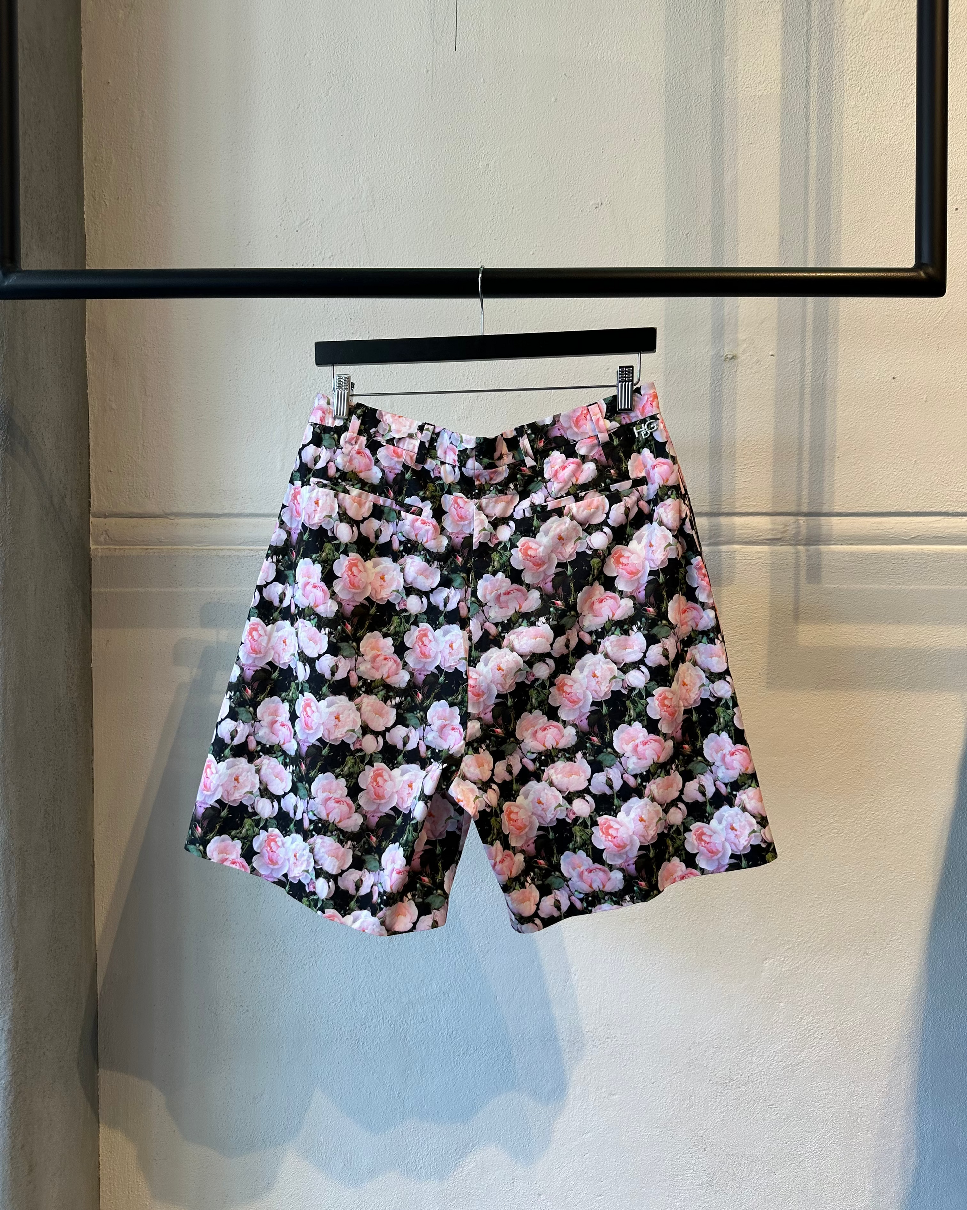 Floral Givenchy shorts on a hanger against a neutral background